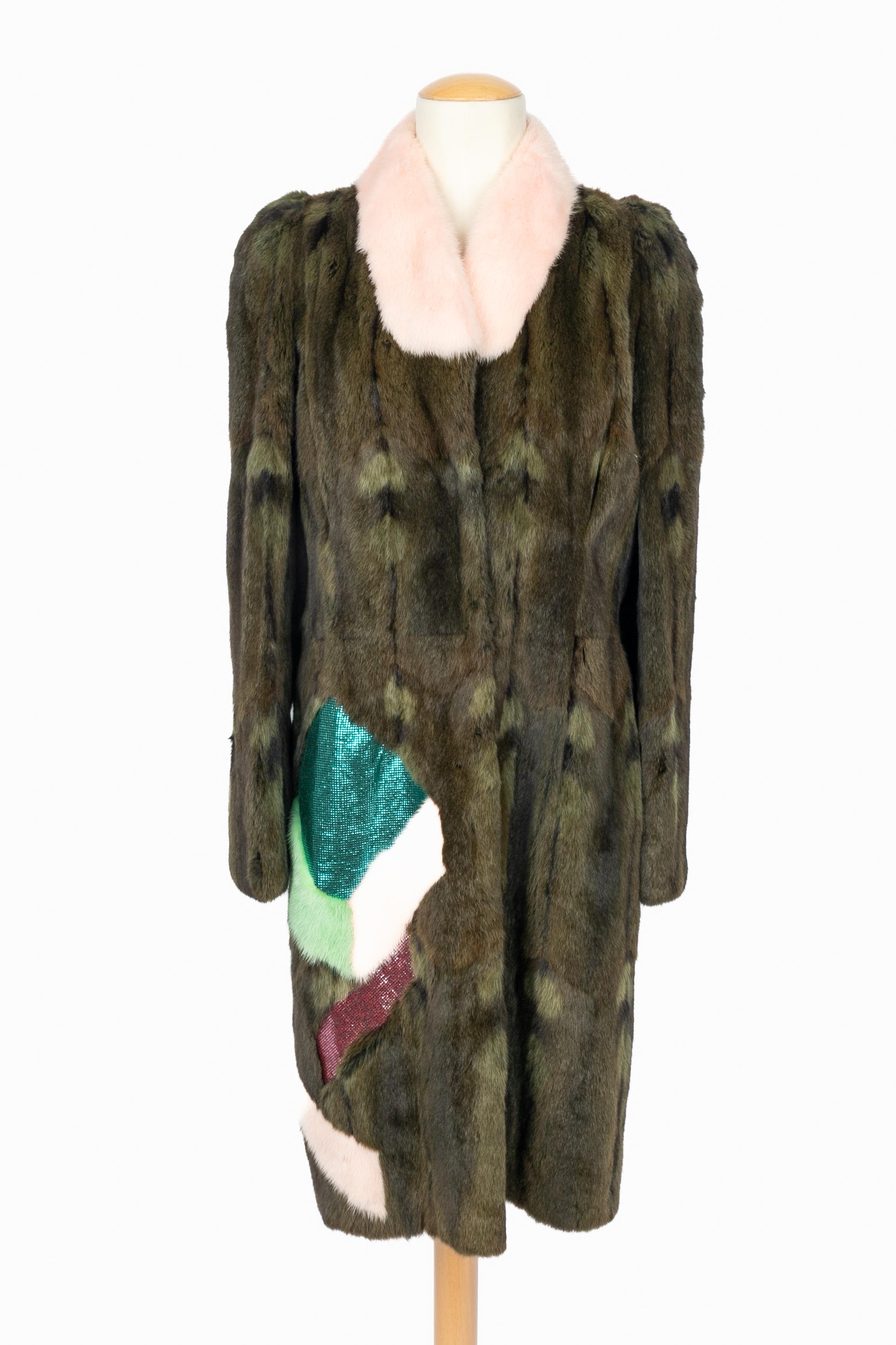 CHRISTIAN LACROIX - (Made in France) Pelliccia di criceto nei toni del verde scuro con colletto rosa e toppe rosa e verdi ornate da tessuto a squame blu e rosa. Taglia 40FR indicata. Collezione Autunno-Inverno 2000 sotto la direzione artistica di