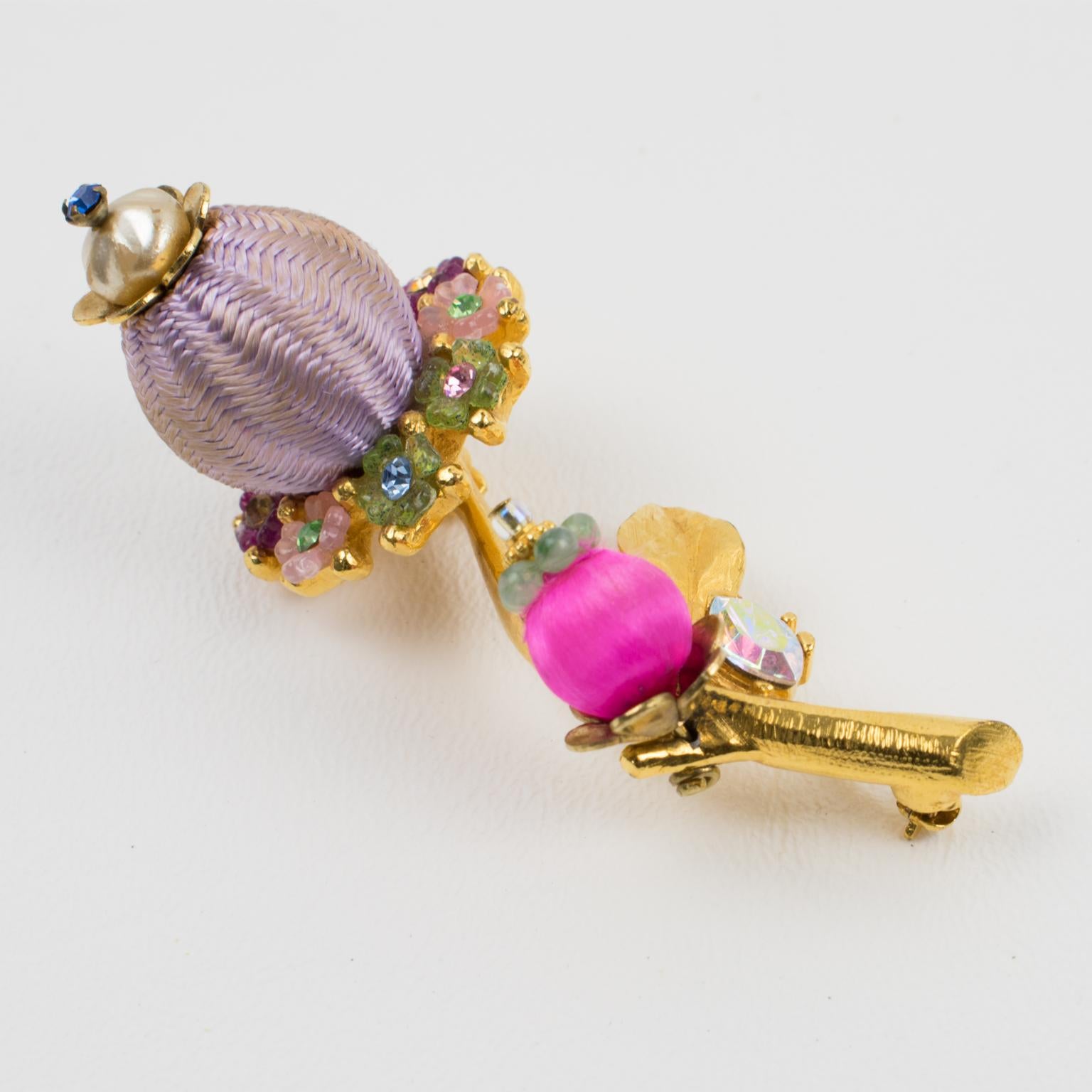 Charming Christian Lacroix Paris signed pin brooch. A jeweled floral shape with gilt metal all textured and ornate with multicolor crystal rhinestones. Stylized flowers are also complemented with lavender and hot pink silk and pearl-like beads.