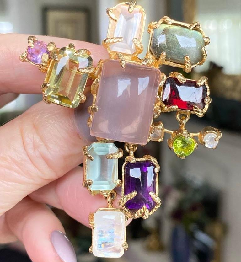 A fabulous designed Cross brooch by Christian LaCroix.

The abstract Cross design, so favoured by LaCroix, is set with semi precious cabochon stones, opal, rock crystal and rose quartz, with tourmaline, peridot, pale aqua, amethyst and garnet