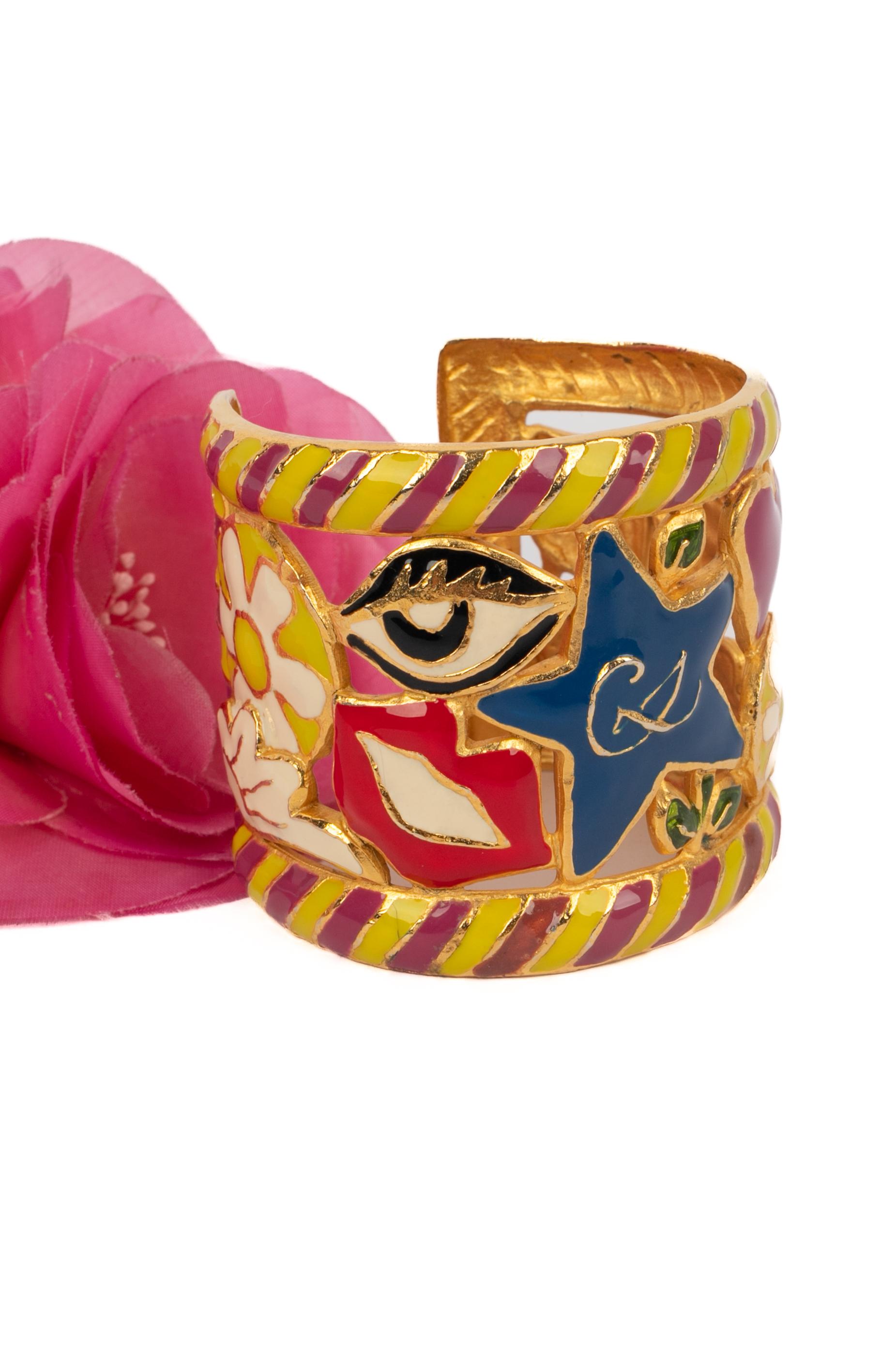 CHRISTIAN LACROIX - (Made in France) Goldenes Manschettenarmband aus Metall mit mehrfarbiger Emaille.

Bedingung:
Sehr guter Zustand

Abmessungen:
Länge: 14 cm - Öffnung: 3 cm

SKU:BRA101


