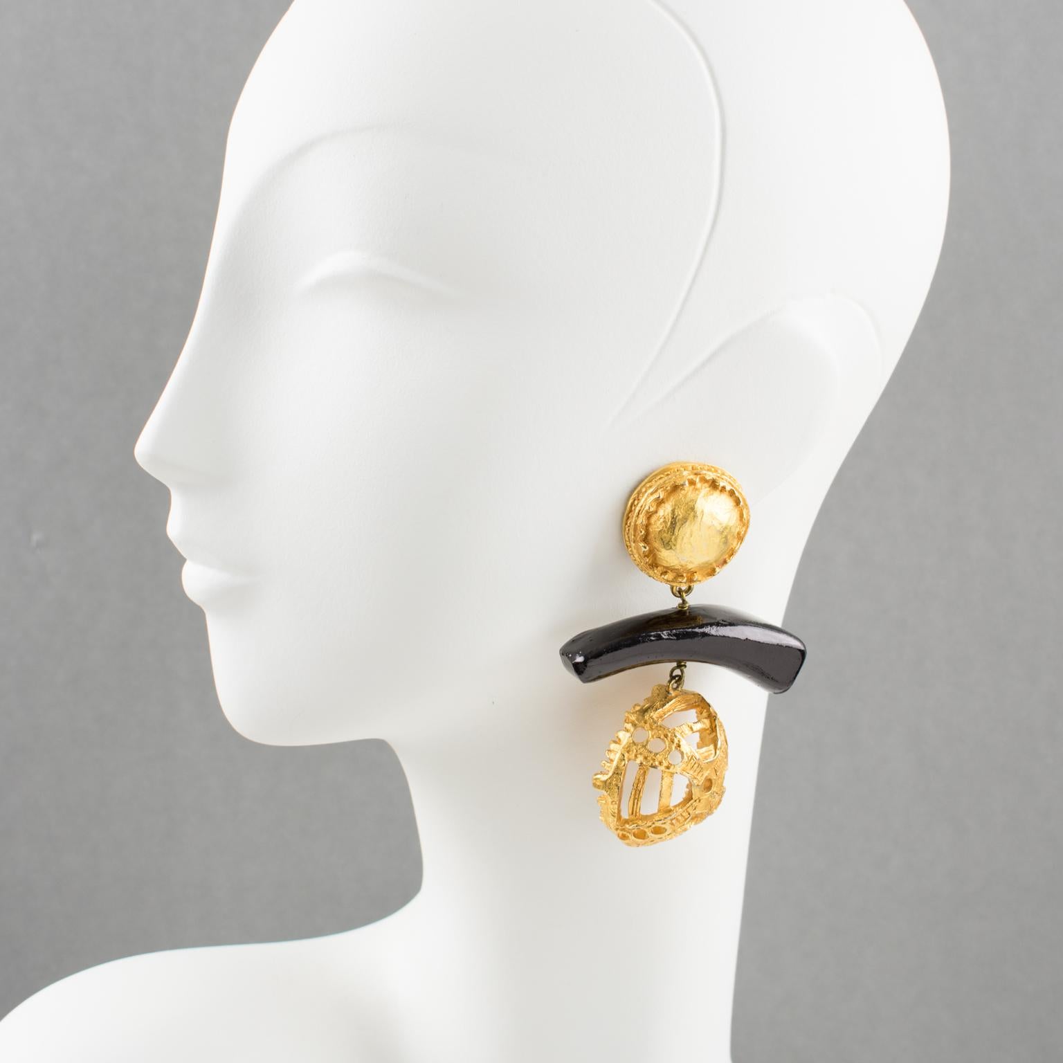 Stunning Christian Lacroix Paris signed tribal clip-on earrings. Oversized gilt metal dangling shape, metal all textured and see thru, ornate with a large varnish carved wood element. Signed on the gilded tag at the back: 'Christian Lacroix - CL -