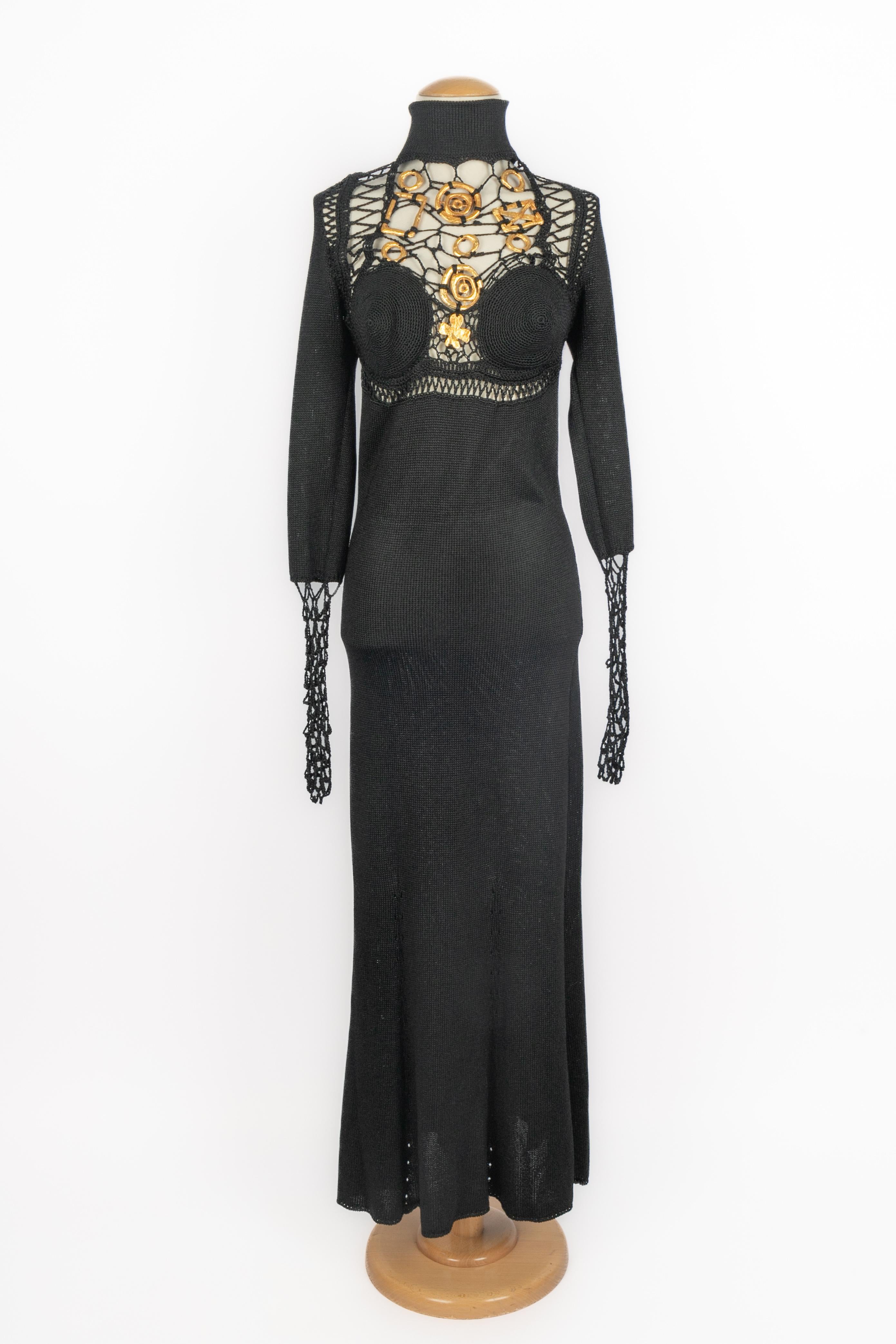CHRISTIAN LACROIX - (Fabriqué en France) Robe à manches longues en maille noire, poitrine ornée de bijoux en métal doré. Taille 42FR indiquée. Collectional automne-hiver 1993 sous la direction artistique de Christian Lacroix.

Condit :
Très bon