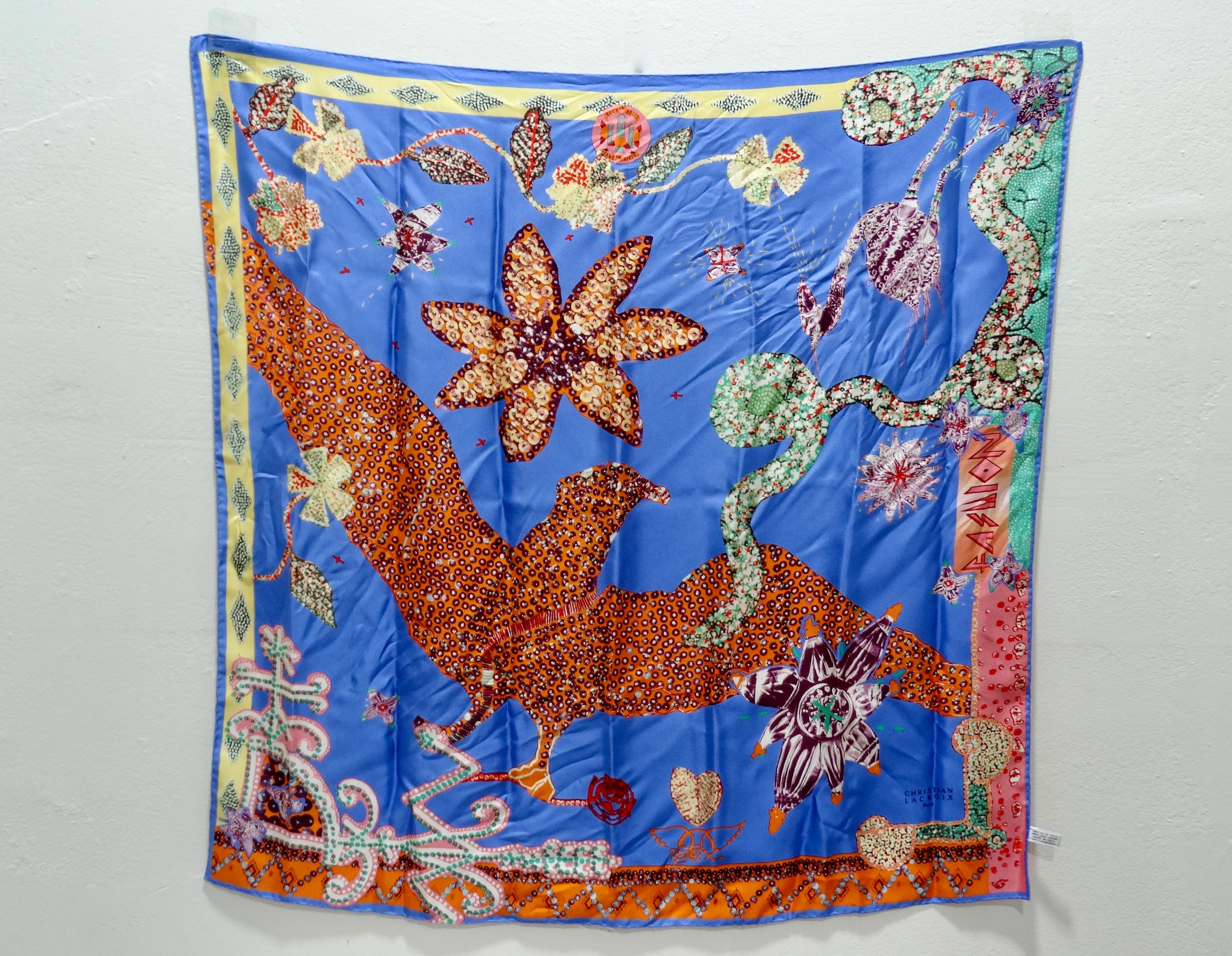 La tua nuova sciarpa preferita è qui! Questo foulard di seta, risalente alla fine degli anni '80/inizio anni '90, presenta un motivo di uccello stampato con paillettes e decorato con fiori, cuori e altri disegni. Sul lato è stampata la scritta