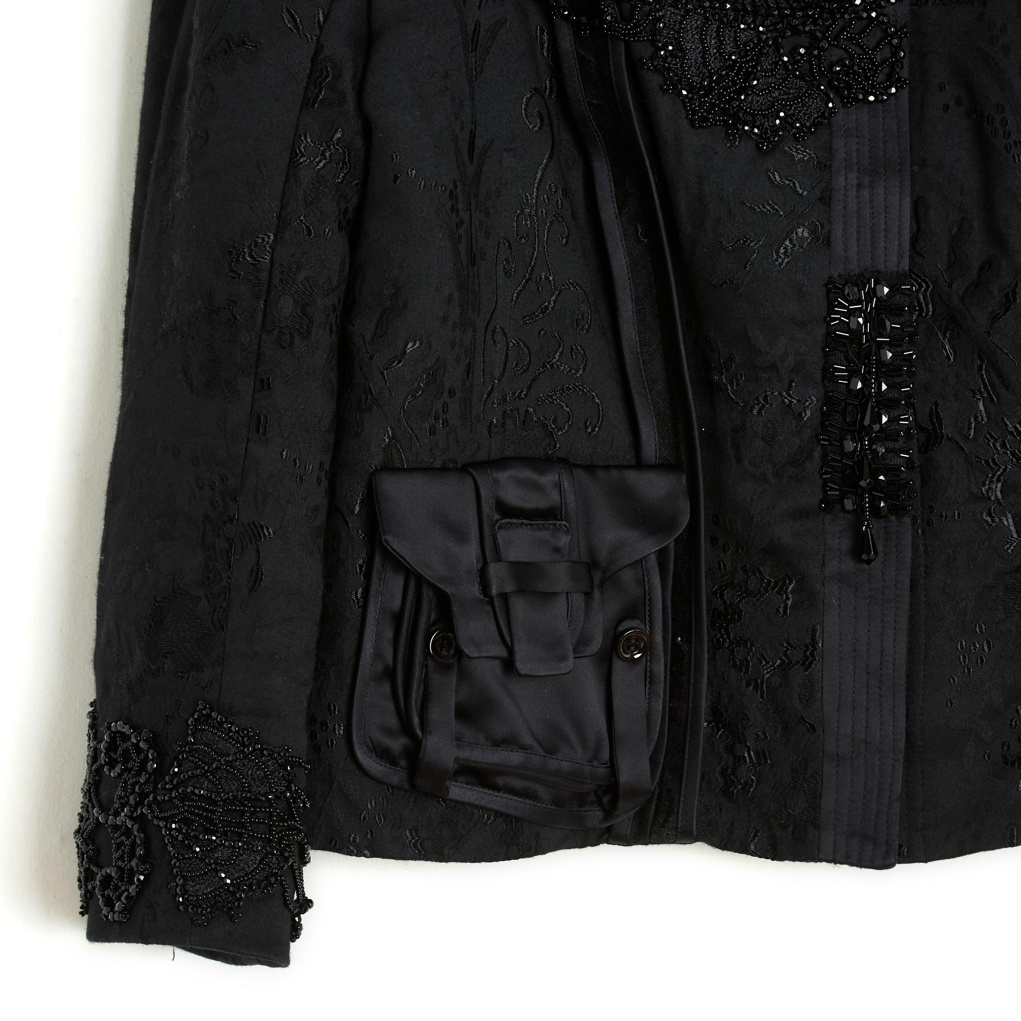 Giacca Christian Lacroix, collezione A Winter 2006 in cotone nero e lana damascata, collo arrotondato leggermente alto e pad chiuso da 6 ganci, 2 tasche con patta in tela di raso, maniche raglan a 2/3, pettorina e fondo delle maniche ricamati con