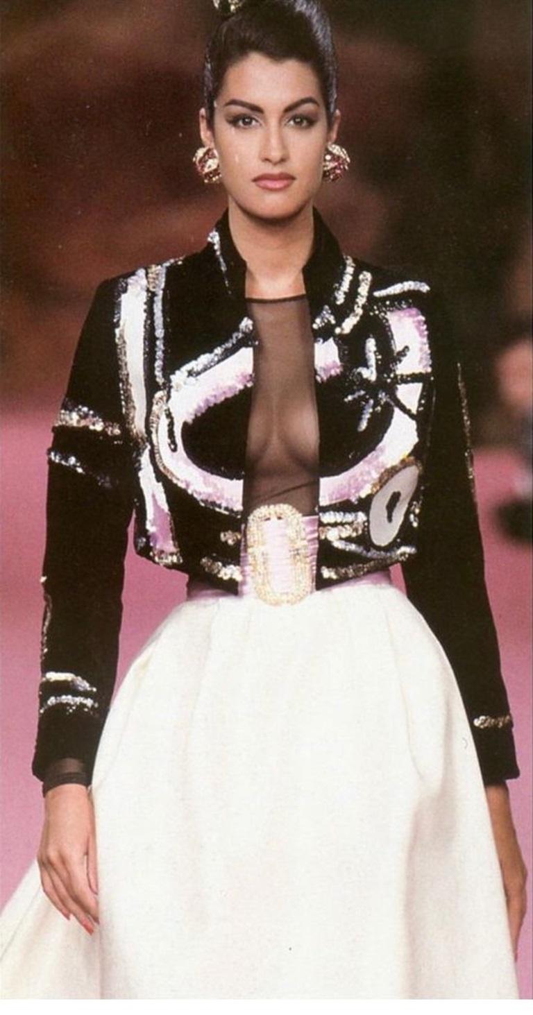 Christian Lacroix - Haute Couture Set bestehend aus einer schwarzen, mit Pailletten bestickten Samtjacke, einem transparenten Body, einem Rock und einem Seidengürtel. Keine Größenangabe, es passt eine 36FR.
Collection Haute Couture Automne-Hiver