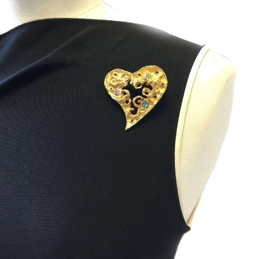 Very beautiful Christian Lacroix heart brooch in gold metal set with three rhinestones: pink, green and blue.

In perfect condition. Made in France

Dimensions: 5.5x5 cm

Will be delivered in a new, non-original dust bag