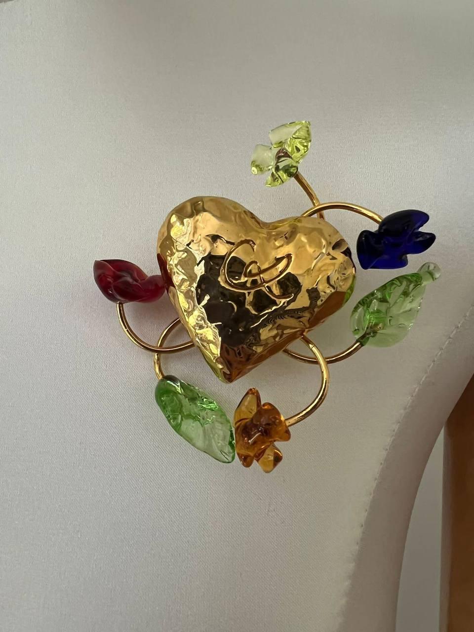 Signature structured gold-tone metal brooch in the form of heart with CL signature by Christian Lacroix. Elevated with blue, red and yellow glass flowers and green petals on metal twigs. 
Signed. 
Period: 1990s
Condition: excellent
Diameter: 7cm