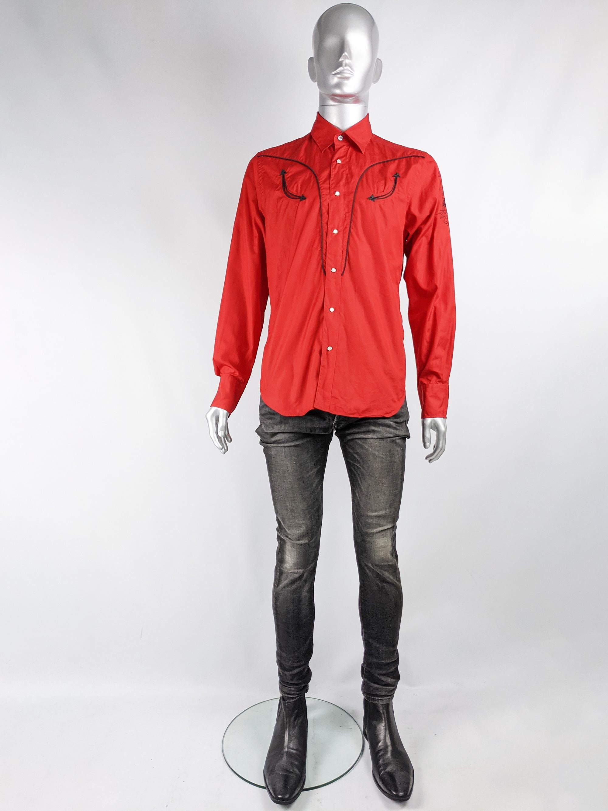A stylish vintage mens long sleeved shirt from the early 2000s by luxury French fashion designer, Christian Lacroix. In a bold red cotton fabric with a bull embroidery on the sleeve, pearl snap buttons and black binding on the pockets that give a