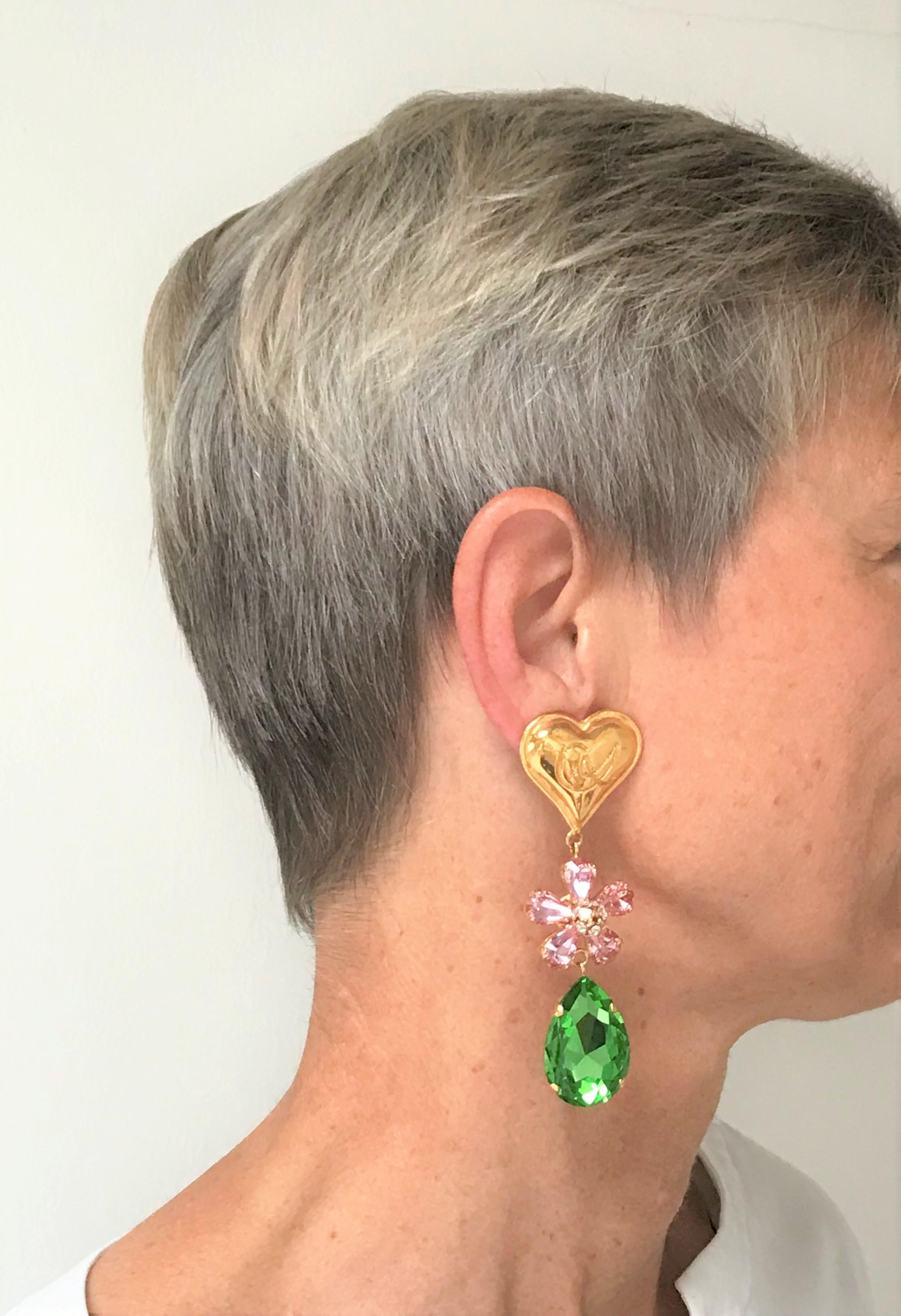 A beautiful ear clip from Christian Lacroix Paris. Consists of the famous Lacroix heart with a flower in rose rhinestones and a large green rhinestone dripping from it. A summer dream!
Measurement: Full length 9 cm/3.5