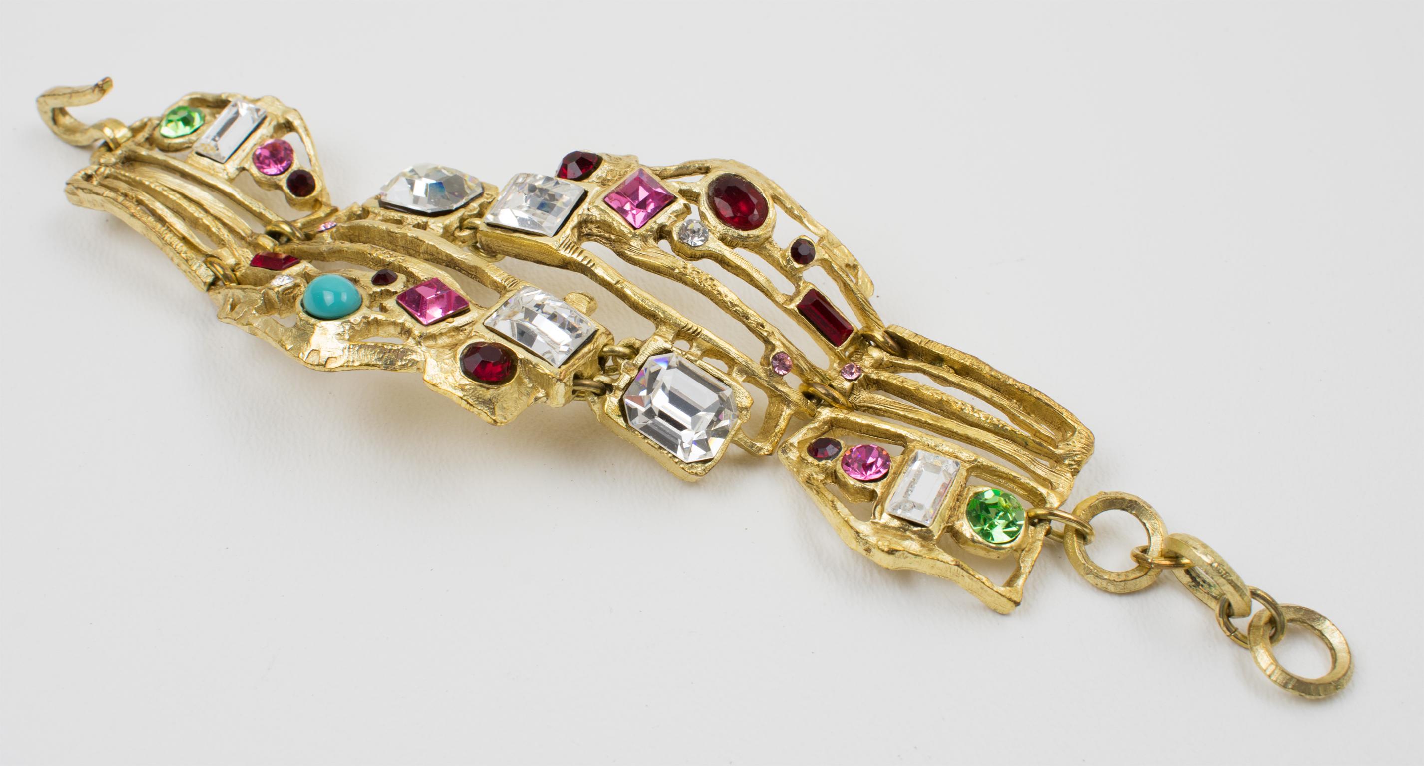 This sophisticated Christian Lacroix Paris link bracelet features baroque ornamental detailing with a brutalist design. The semi-mat gilt metal carved and see-thru with texture framing is embellished with crystal rhinestones in various shapes. There