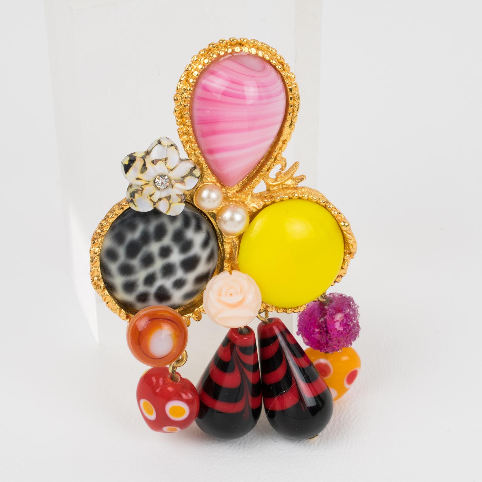 This mesmerizing Christian Lacroix Paris jeweled brooch features a geometric gilded metal framing with dangling charms, ornate with pearl-like, poured glass cabochons and pate de verre drop beads. The rare piece has superb assorted multicolor tones