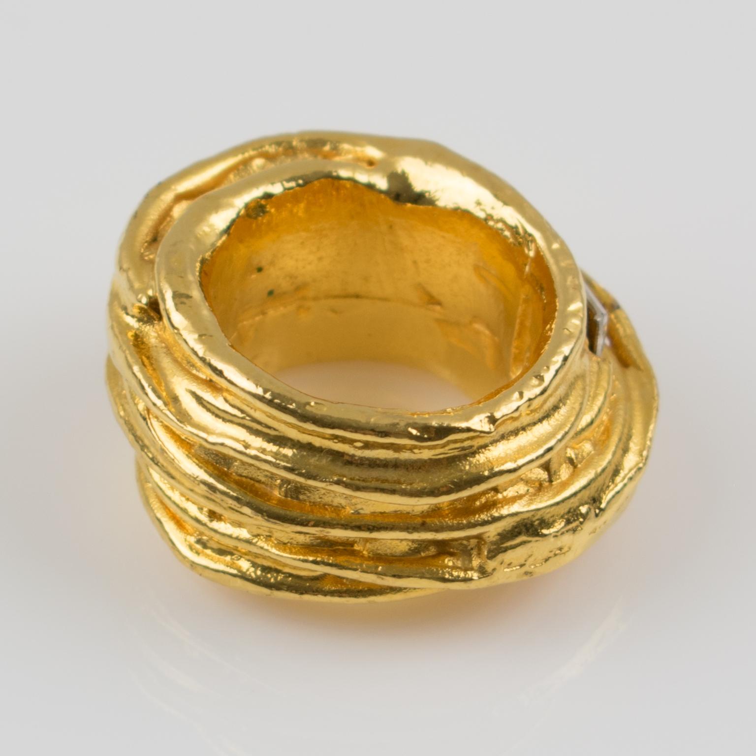 Elegant ridged baguette crystal ring by Christian Lacroix Paris. Large gold plated band shape with hammered and textured metal ornate with crystal rhinestones baguette of different sizes. Signed in the inside with the Lacroix logo. 
Measurements: