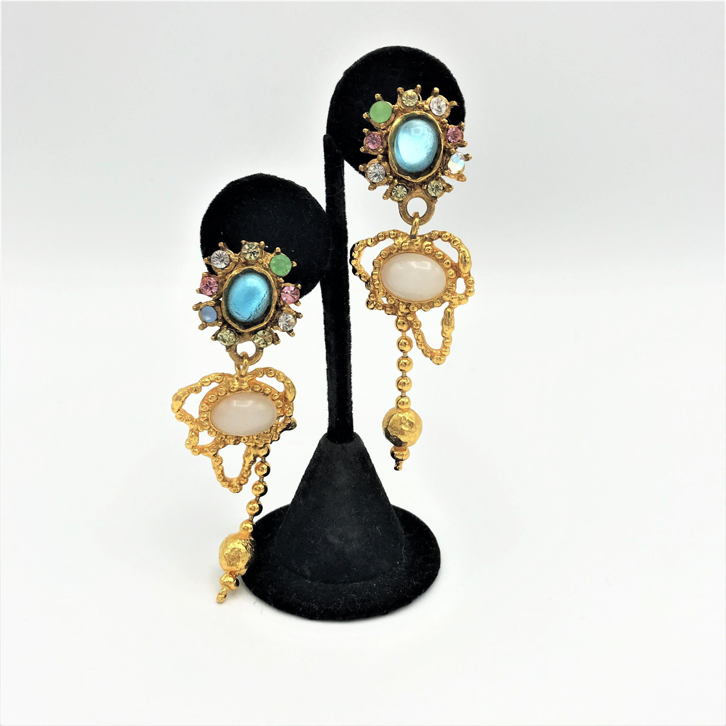 Beautiful feminine hanging ear clips by Ch. Lacroix. The upper part is covered with colorful rhinestones. On it hangs a moving part with white opal stone/imitation. 
Measurement: Length 8 cm, the upper part with the turquoise stones measures