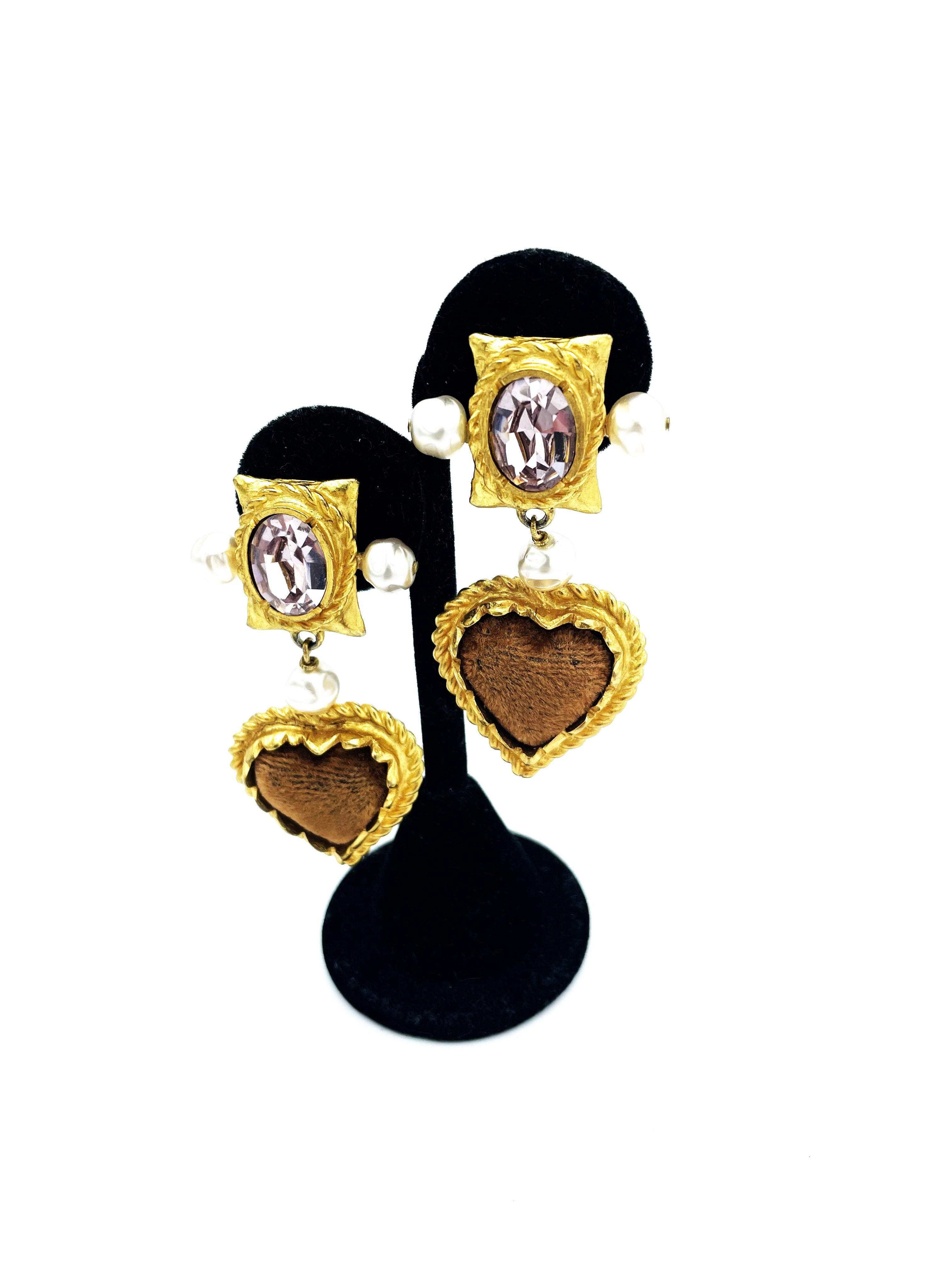 About
Hanging ear clip by Ch. Lacroix Paris consisting of 2 parts. The upper part with a large, slightly lavender colored cut rhinestone with 2 handmade pearls on the site. Hanging on it are 1 pearl and a gold heart bordered with a cord and filled