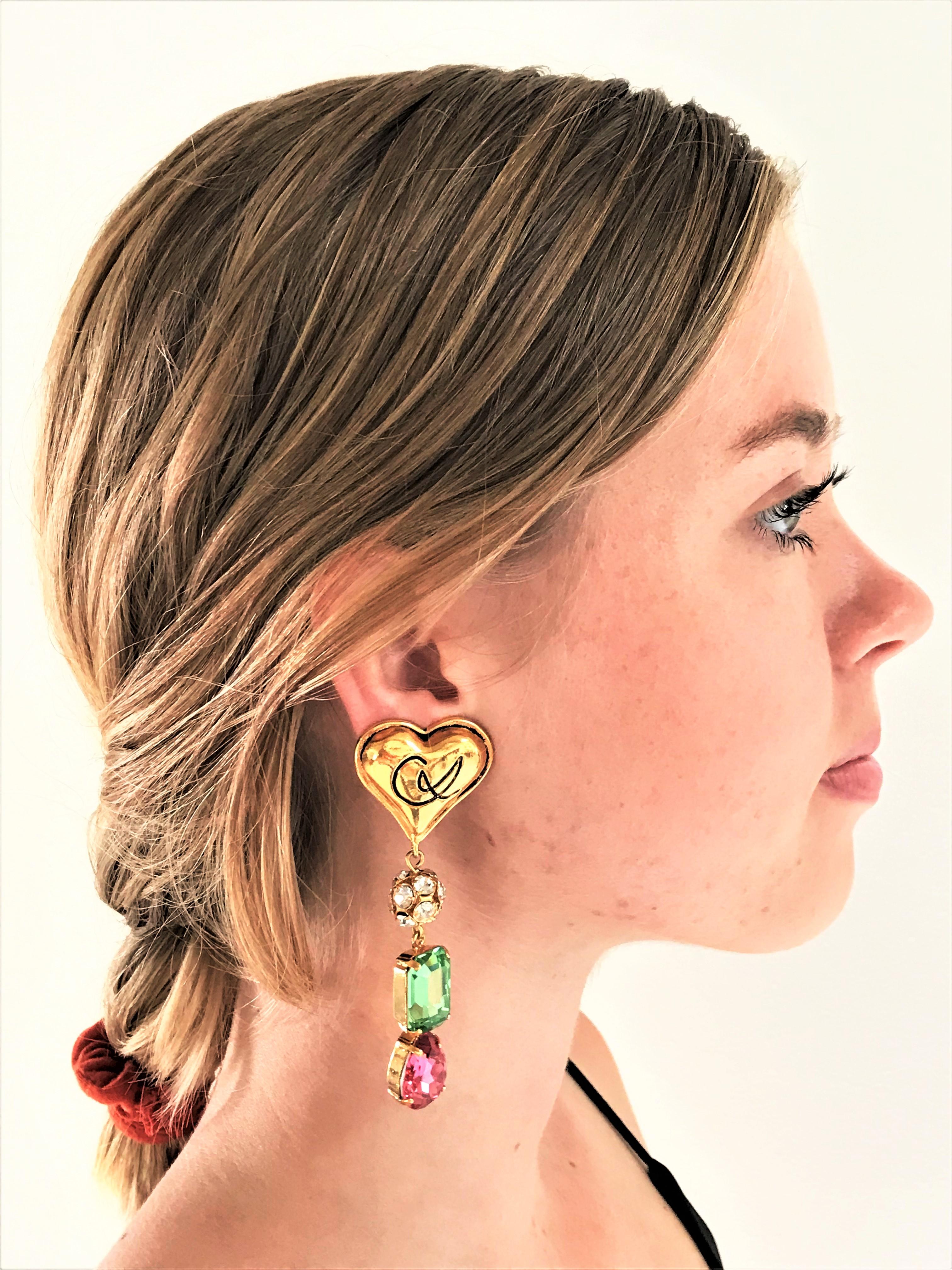 A pair of very decorative Lacroix ear clips. On top the famous Lacroix heart, hanging from it a ball studded with rhinestones, then a set and cut green rectangular rhinestone stone and a pink cut rhinestone drops.
Measurement: Full length