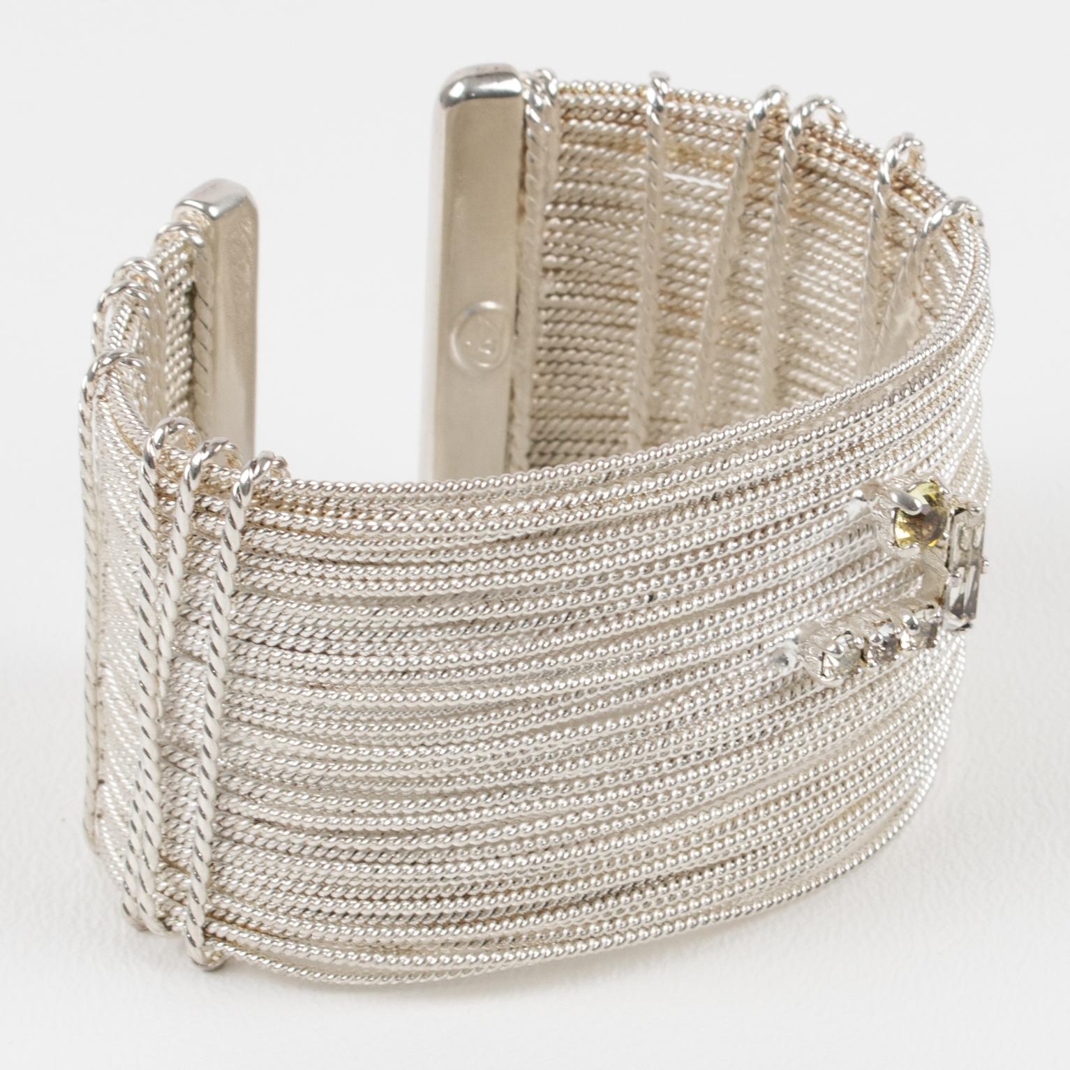 This sculptural Christian Lacroix Paris bracelet bangle features a silver-plate cuff shape with a multi-wire design ornate with larger metal ropes on the sides and embellished with a 