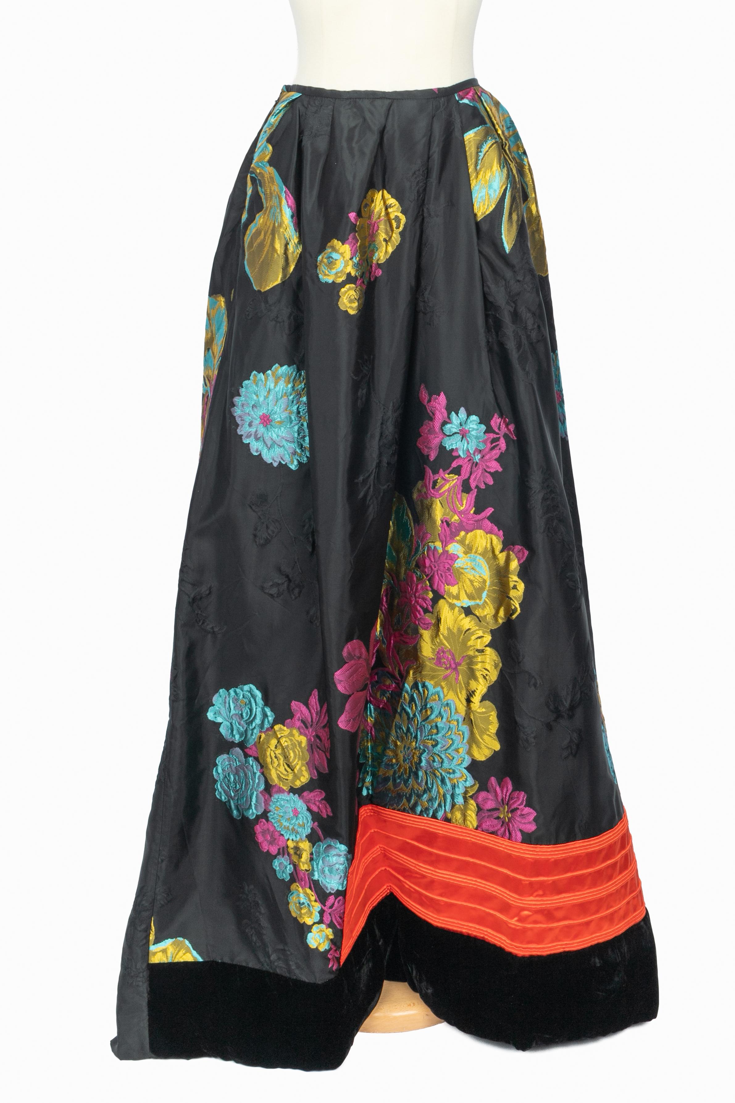 CHRISTIAN LACROIX - (Made in France) Black taffeta set brocaded with multicolored plant pattern, composed of a jacket and a wide skirt. Size 38FR/40FR. 1999-2000 Fall-Winter Collection under the artistic direction of Christian Lacroix. Piece from