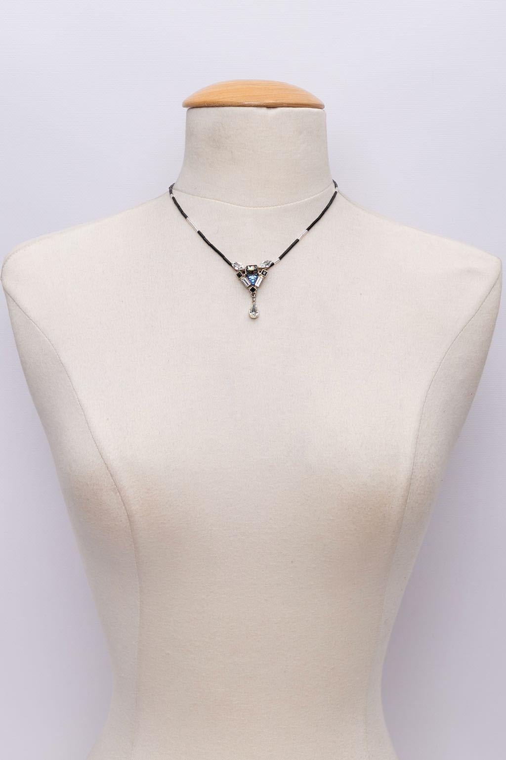 Christian Lacroix - (Made in France) Kurze Halskette aus röhrenförmigen Perlen, an der ein versilberter, mit Strasssteinen und Perlen besetzter Anhänger hängt.

Zusätzliche Informationen:
Zustand: Sehr guter Zustand. Oxidation des Metalls auf der