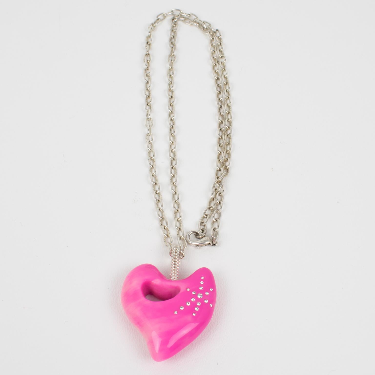 This lovely Christian Lacroix Paris pendant necklace features a long silver plate chain complimented with a dimensional resin heart ornate with crystal rhinestones. Fabulous hot pink color, all marbled and swirled. The pendant has silvered metal