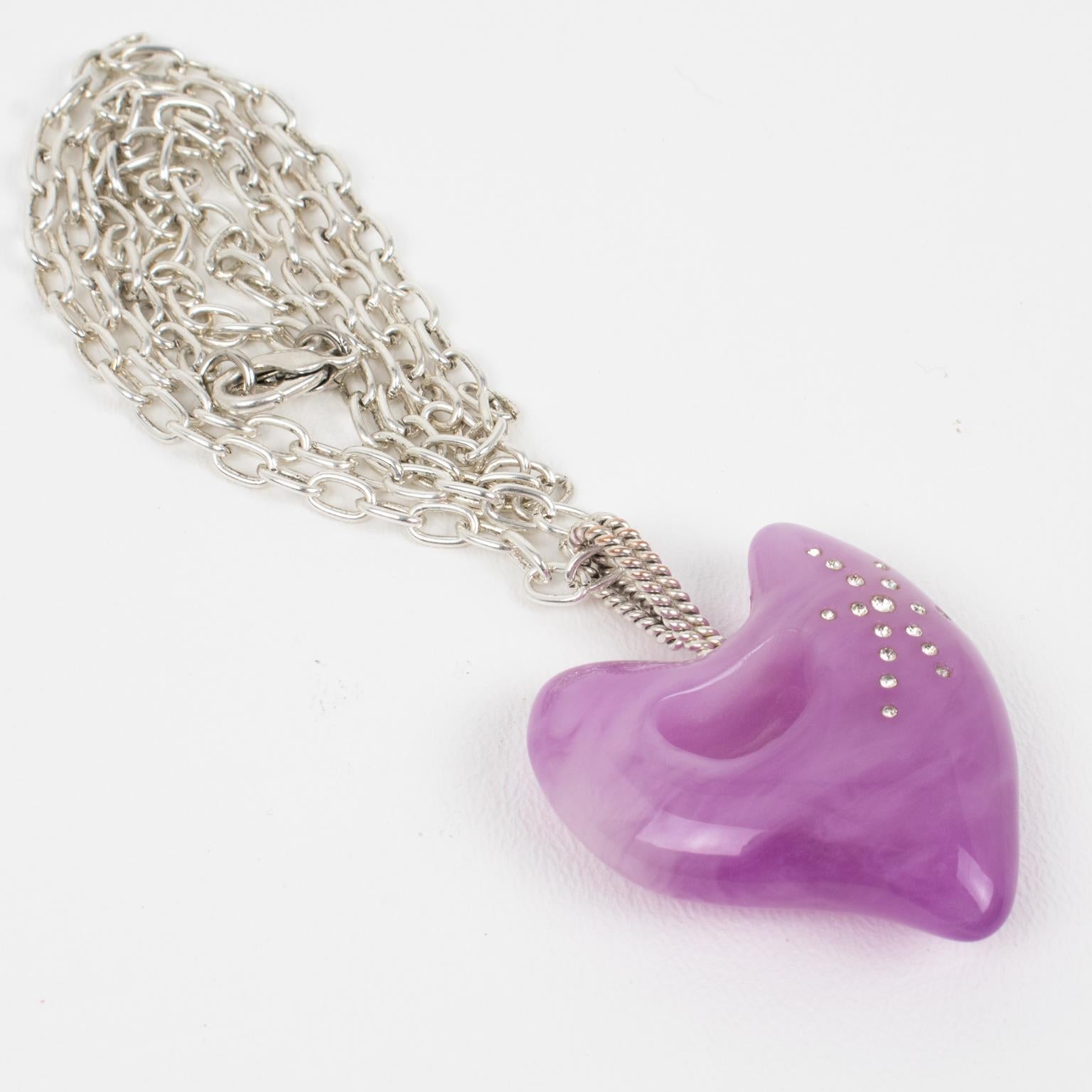 This stunning Christian Lacroix Paris pendant necklace features a silver plate long chain complimented with a dimensional resin heart ornate with crystal rhinestones. Fabulous lavender purple color, all marbled and swirled. The pendant has silvered