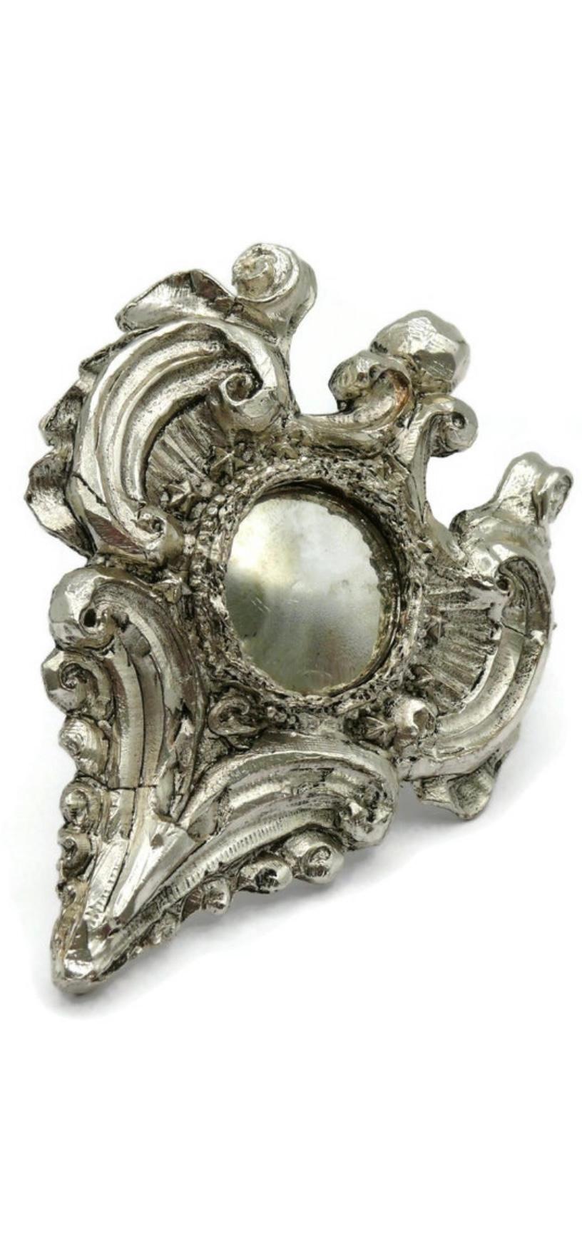 Rare CHRISTIAN LACROIX vintage silver plated Brooch in the shape of a medallion with a little »sorcière » mirror.

Can be used as a brooch or pendant.

Embossed Noel 2007 (for « Christmas 2007 »)

Sign : CL (Christian Lacroix)

Indicative