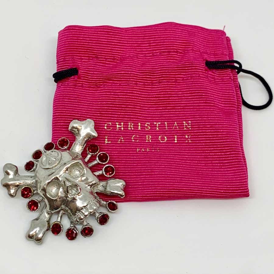 Brooch in the shape of a skull called Vanity, from Maison CHRISTIAN LACROIX in silver metal and set with ruby ​​colored rhinestones.
Made in France.
This brooch is in very good condition.
Its dimensions are as follows: 5x5 cm
The CHRISTIAN LACROIX