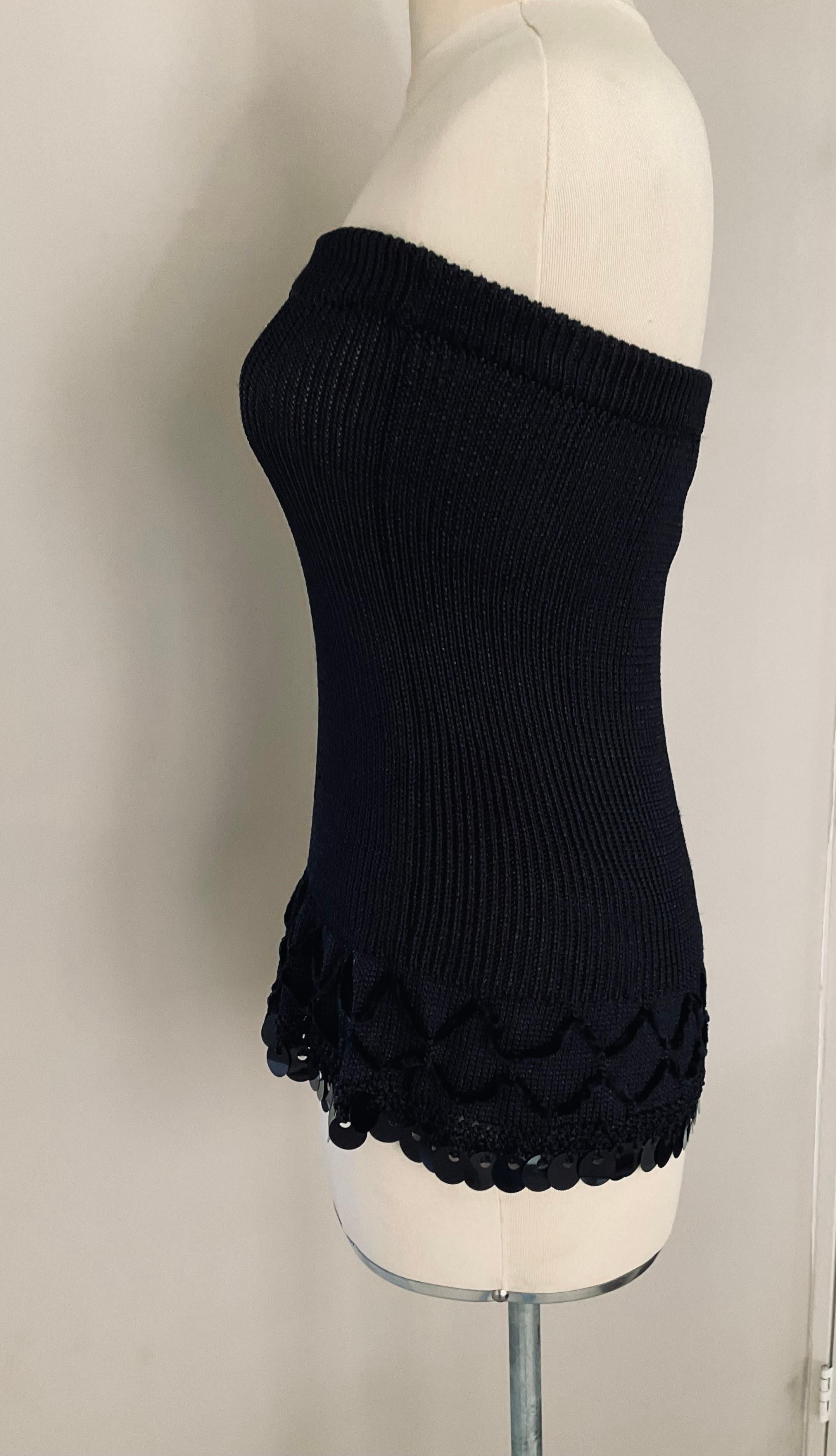 This exquisite strapless black top by Christian Lacroix captures the designer’s signature blend of elegance and theatrical flair. Expertly tailored, the piece features a sleek, fitted bodice that highlights the silhouette, while the lower section is