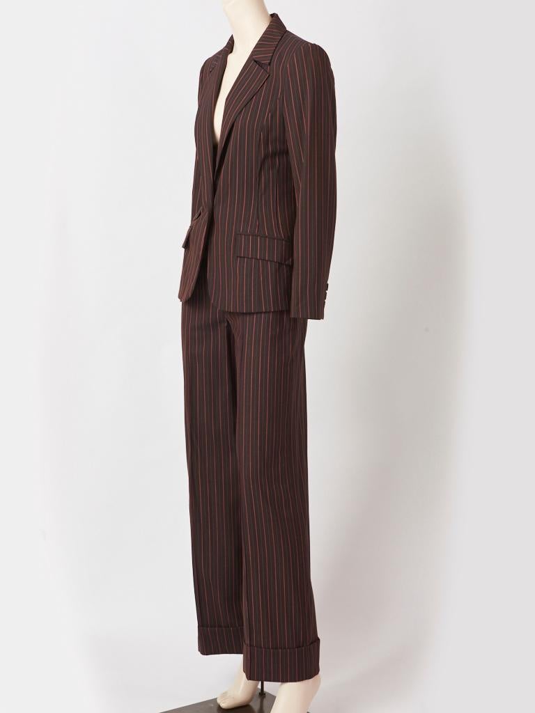 Christian Lacroix, lightweight, stripe masculine style, pantsuit, in a dark chocolate brown having thin stripes in tones of rust, green and nude. Pants have a flat, fly front with slash pockets and cuffs at the legs. Jacket is fitted with flap