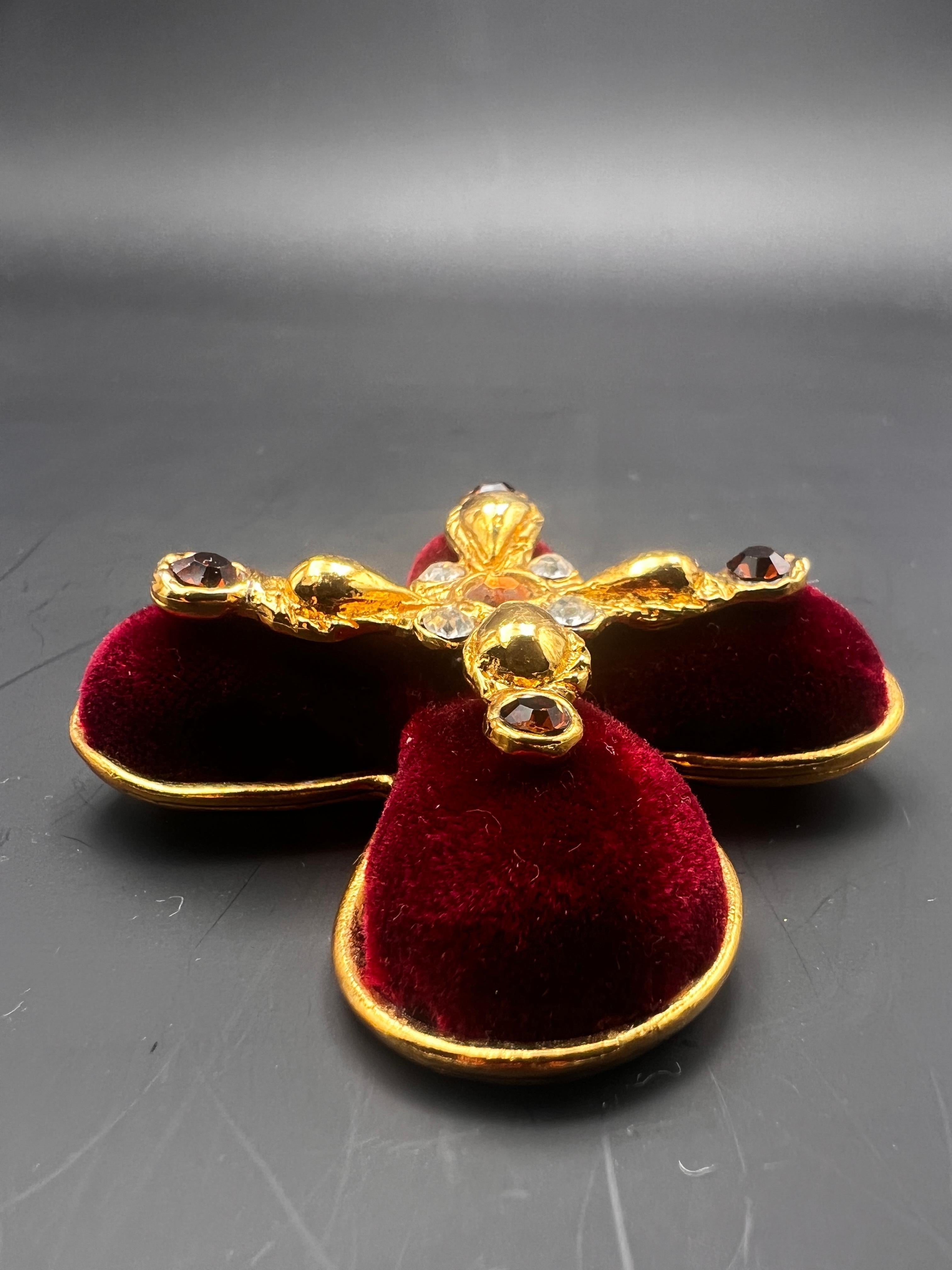 Spilla vintage di Christian Lacroix a forma di croce con placca d'oro, velluto color bordeaux, strass.
Timbro sul retro Christian Lacroix.
Prodotto in Francia.