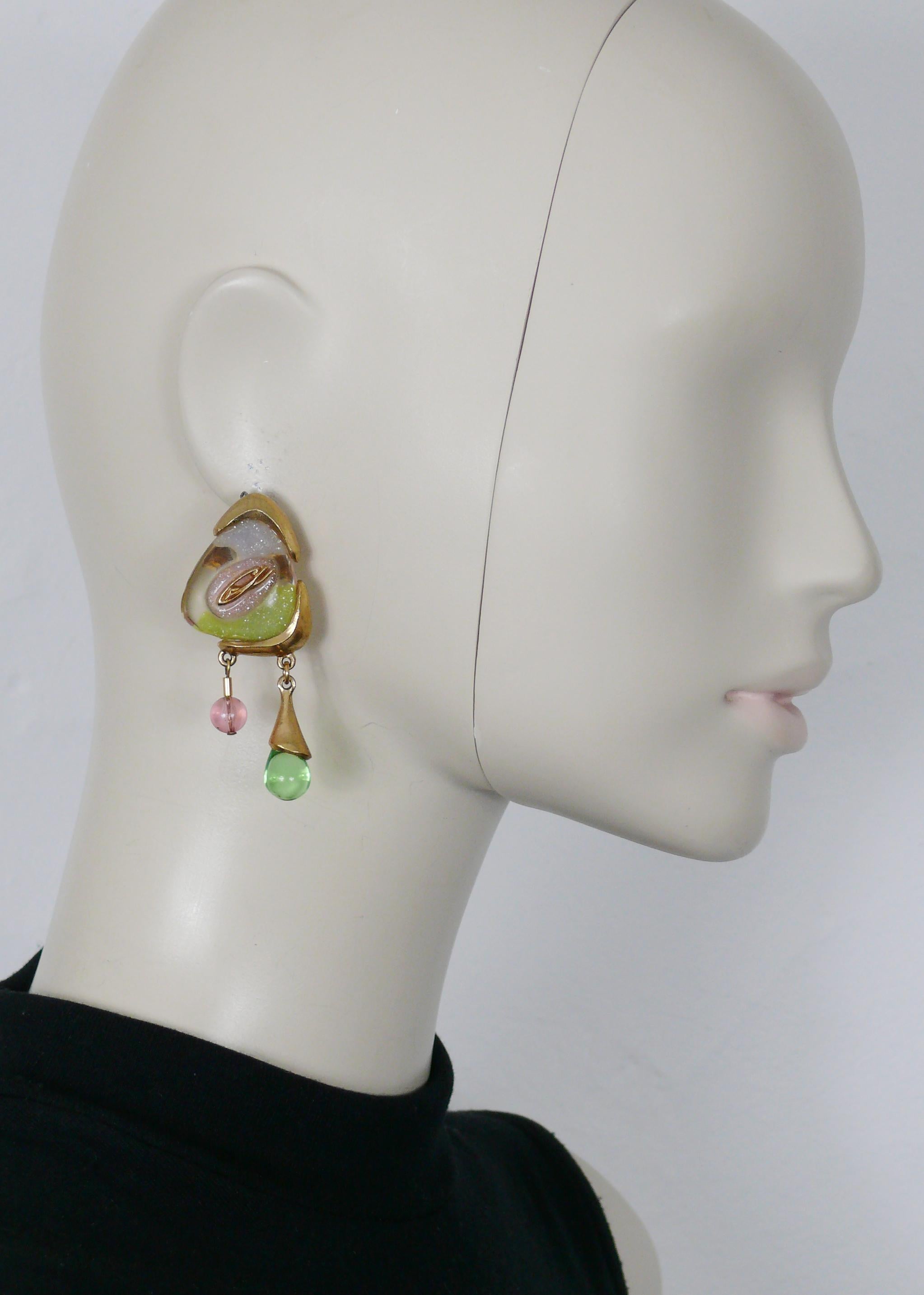 CHRISTIAN LACROIX vintage gold tone abstract design dangling earrings (clip-on) featuring a large clear resin cabochon with glitter inlaids, CL logo and two glass bead charms.

Marked CHRISTIAN LACROIX CL Made in France.

Indicative measurements :