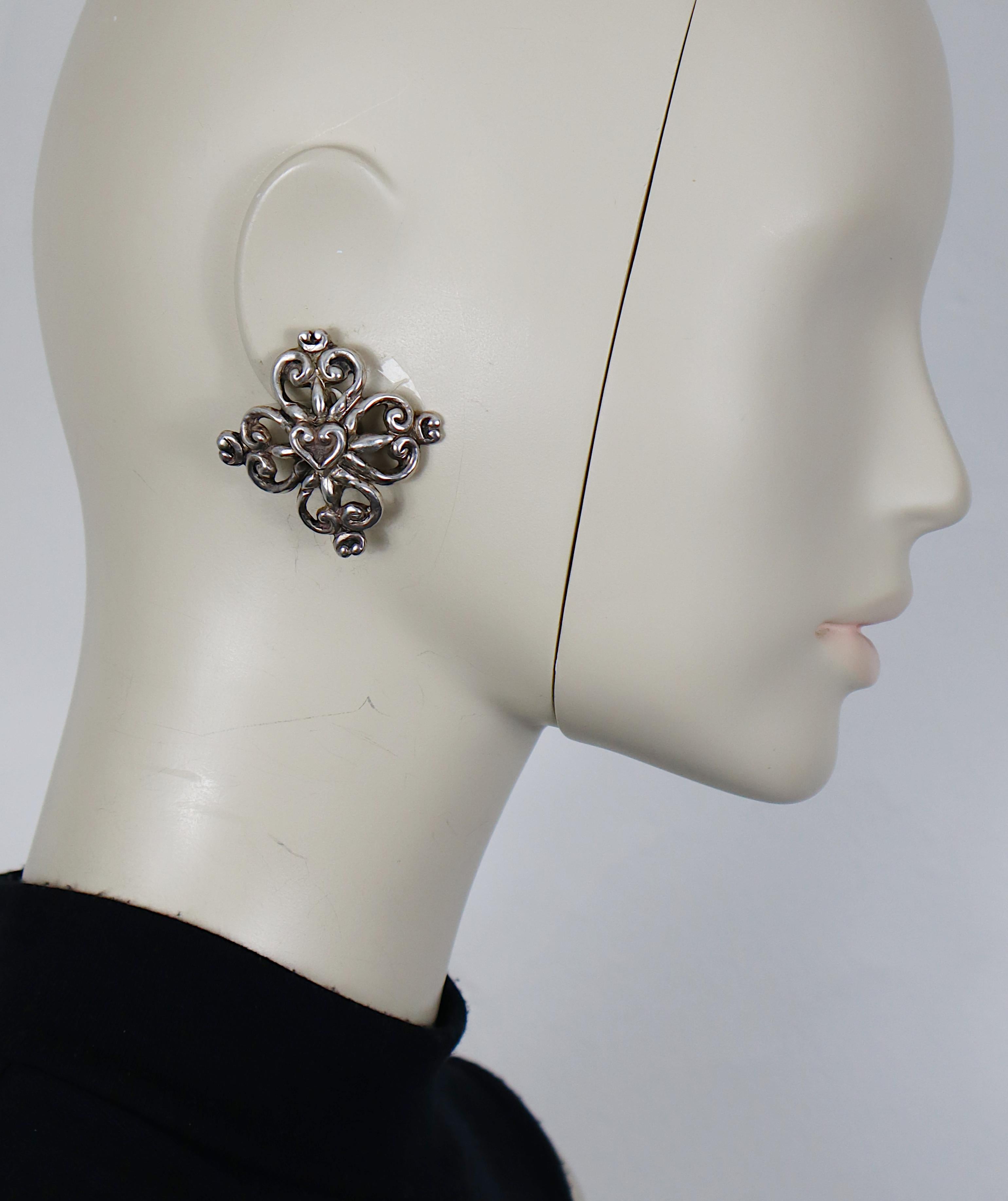 CHRISTIAN LACROIX vintage antiqued silver tone clip-on earrings featuring scroll hearts.

Embossed CHRISTIAN LACROIX E94 Made in France.

Indicative measurements : approx. 4.5 cm x 4.5 cm (1.77 inches x 1.77 inches).

Weight per earring : approx. 16