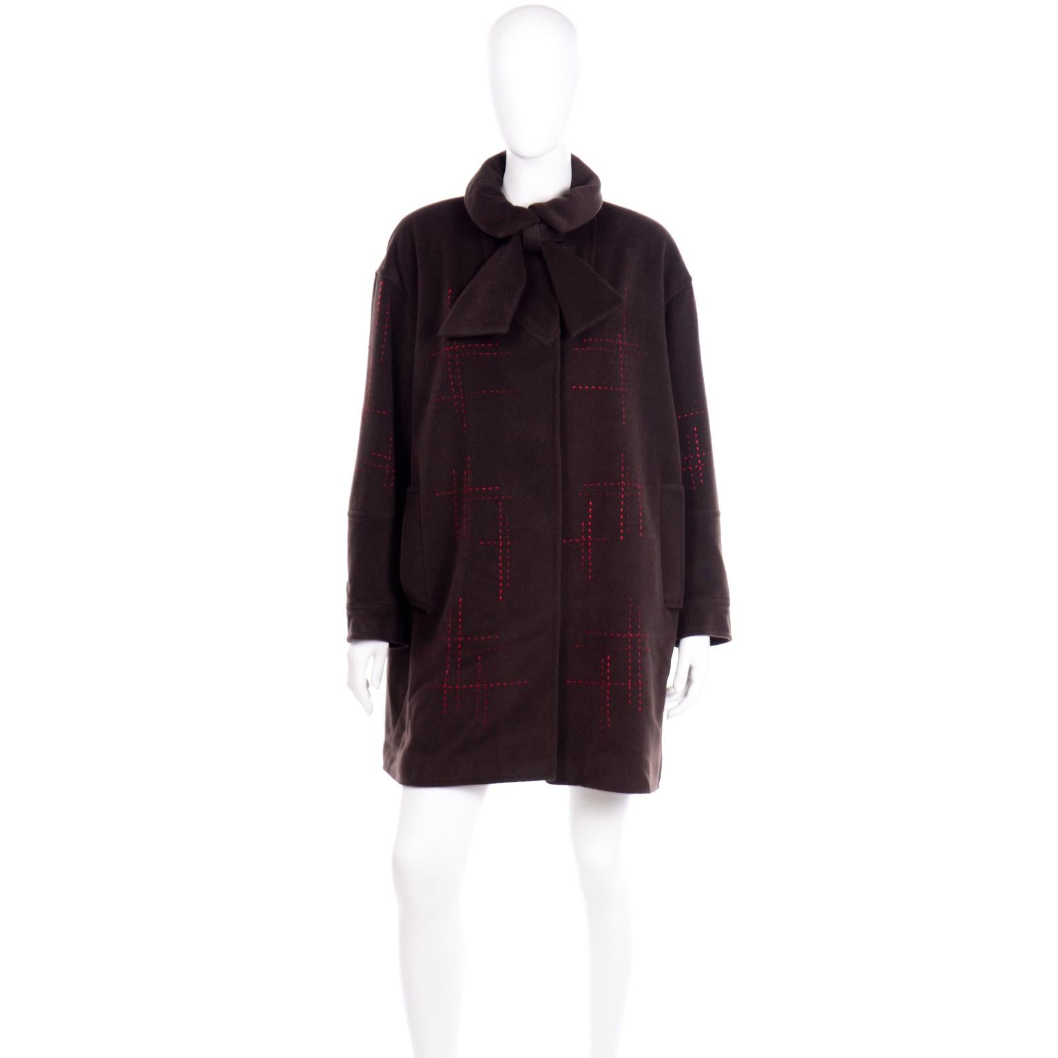 Questo cappotto vintage anni '80 di Christian Lacroix è caratterizzato da un'esclusiva impuntura rossa con un motivo a tratteggio lungo tutta la silhouette. Il colletto ripiegato e appuntito di questa giacca è dotato di pinces e di una cravatta in