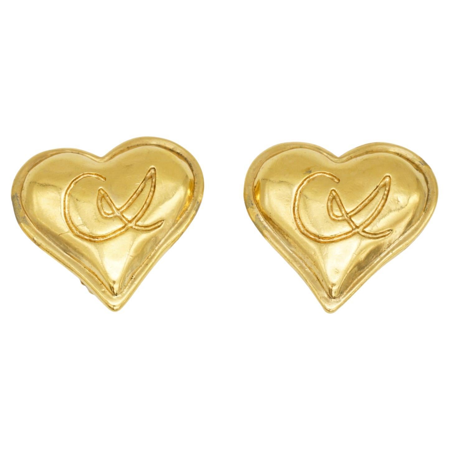Christian Lacroix Vintage 1980s Unisex Classic Cross Logo Monogram Heart Love Glow Clip Earrings, Gold Tone

Very good condition. Light colour loss at side and back. Barely noticeable when wear them. 100% Genuine. 

Signed at the back. Beautiful.