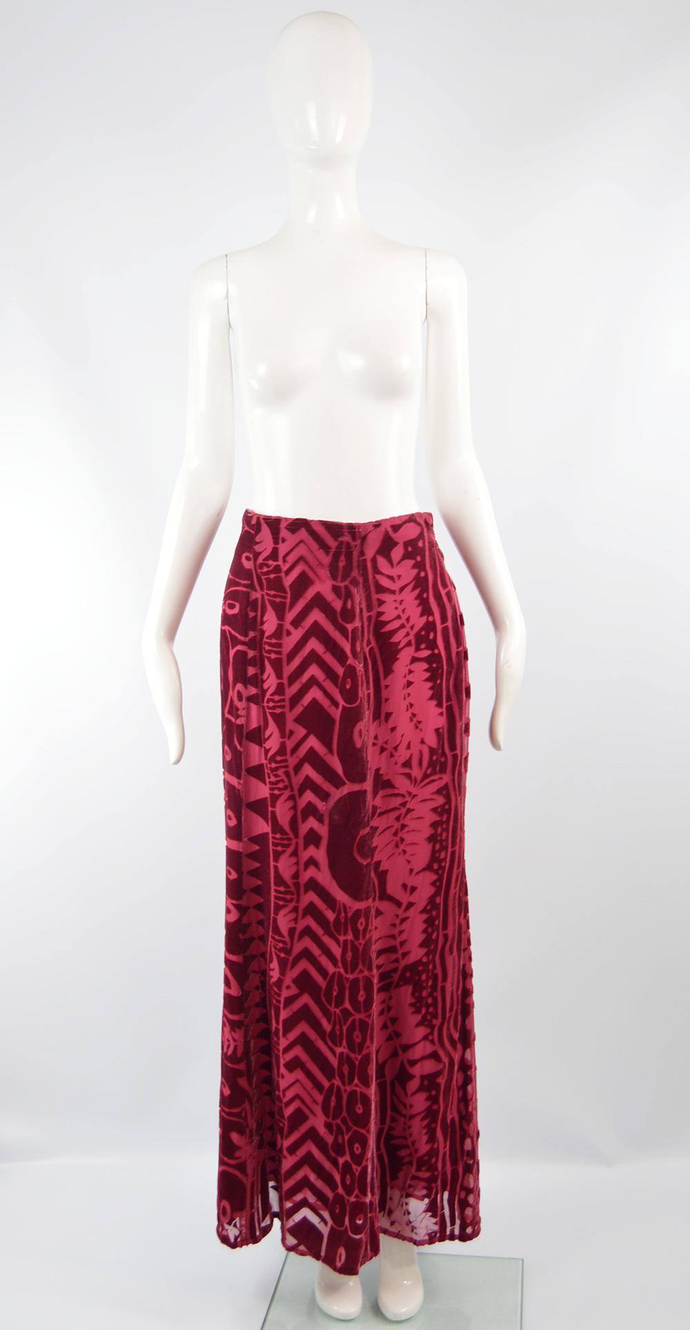 A stunning vintage skirt from the autumn / winter 1997 collection by legendary French fashion designer, Christian Lacroix. In a cranberry / pinkish red silk and rayon blend semi sheer, burnout velvet / devore fabric with a tribal inspired pattern.