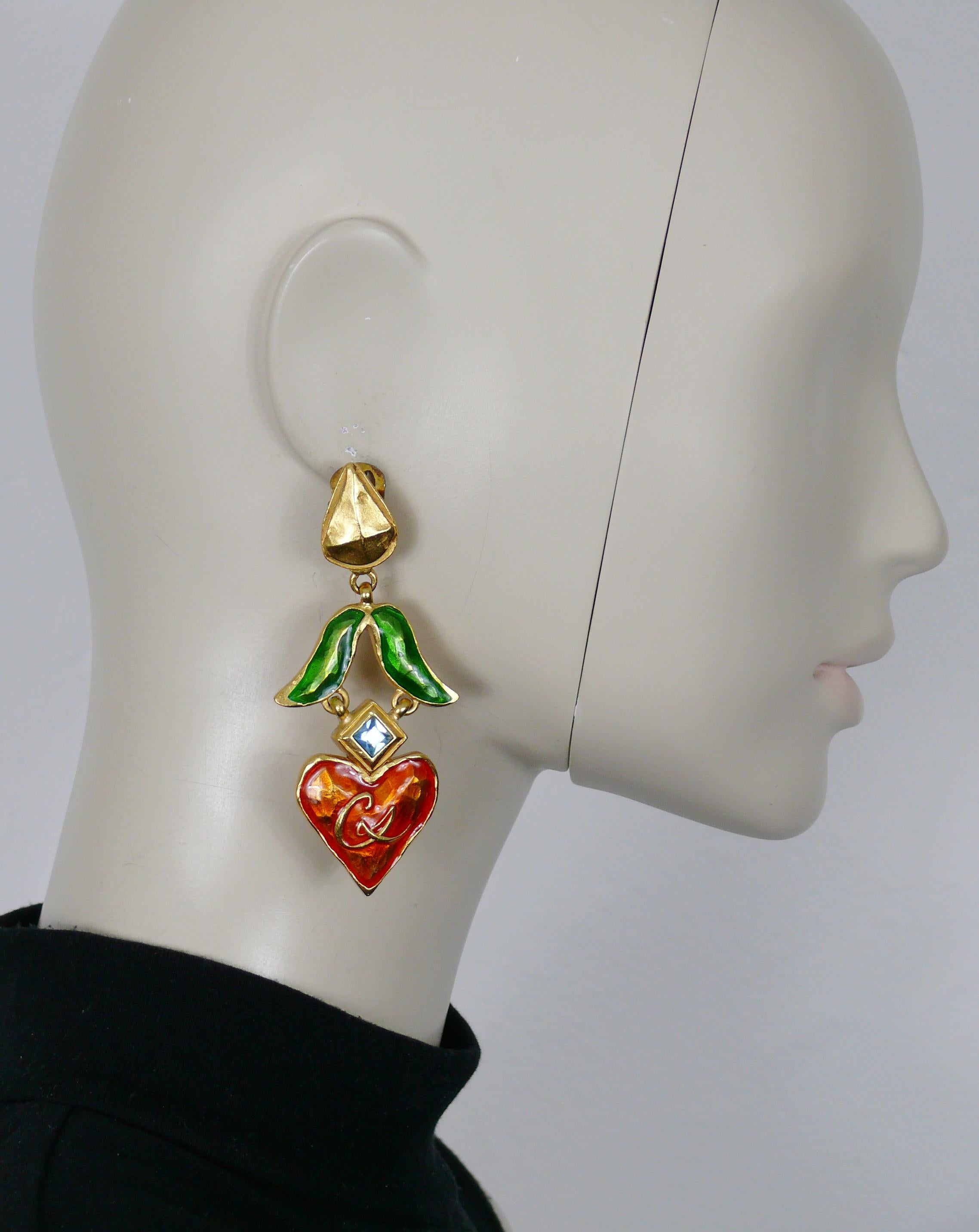 CHRISTIAN LACROIX vintage gold tone dangling earrings (clip-on) featuring a dangle heart with CL monogram embellished with orange enamel and a blue crystal, topped by a green enamel leaf.

Marked CHRISTIAN LACROIX CL Made in France.

Indicative