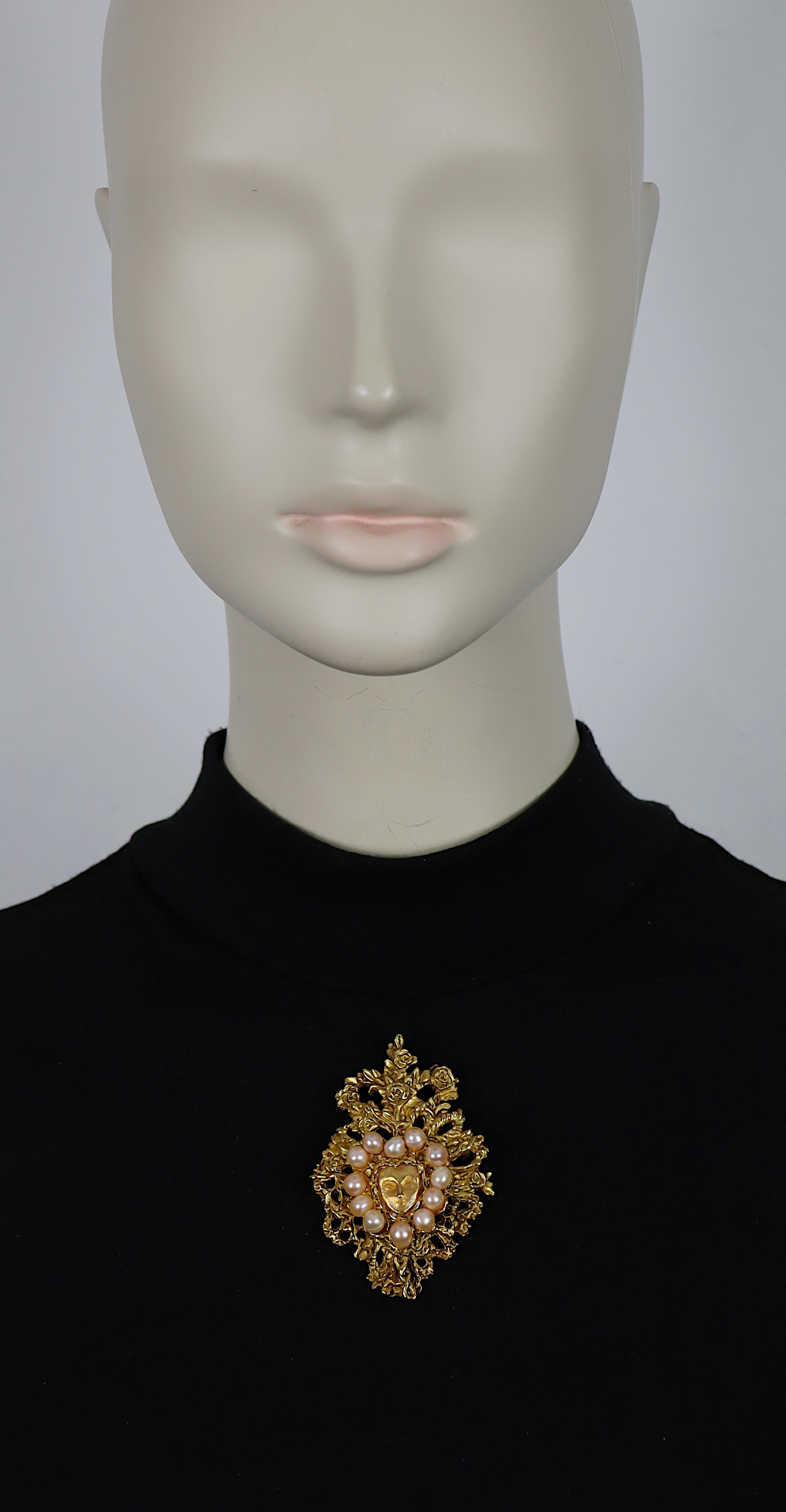 Broche vintage CHRISTIAN LACROIX en ton or présentant un cœur floral rehaussé de fausses perles et un masque au centre.

Édition limitée conçue pour Noël 1998.

Marqué CHRISTIAN LACROIX CL Fabriqué en France.
Embossé NOEL 1998 CL.

Mesures