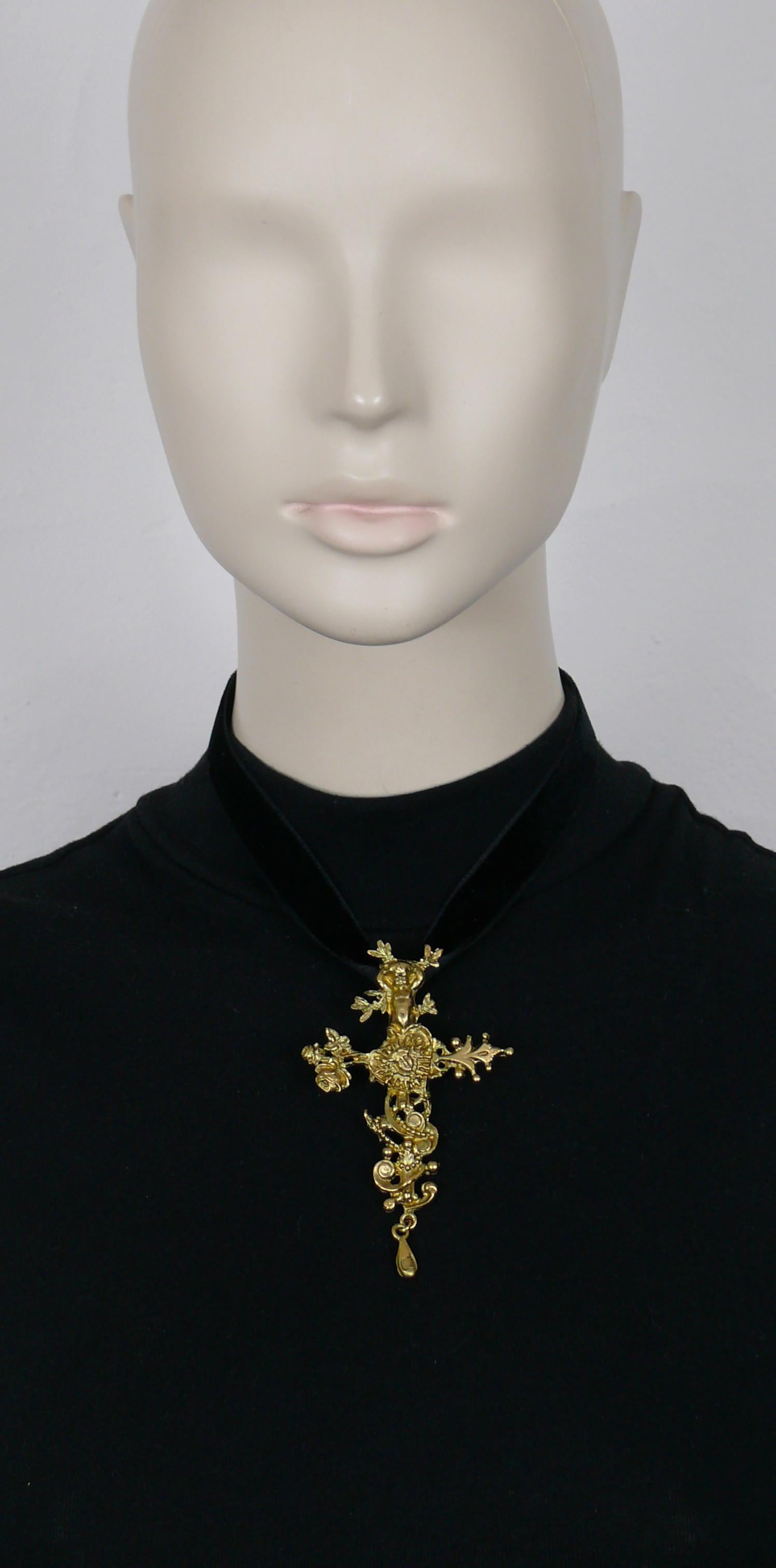 CHRISTIAN LACROIX vintage matte gold tone pendant necklace featuring in a detailed setting a putto, a heart and the allegorical portrait of King Louis XIV founder of the Comedie Francaise.

Black velvet ribbon ties at the neck.

Marked CHRISTIAN