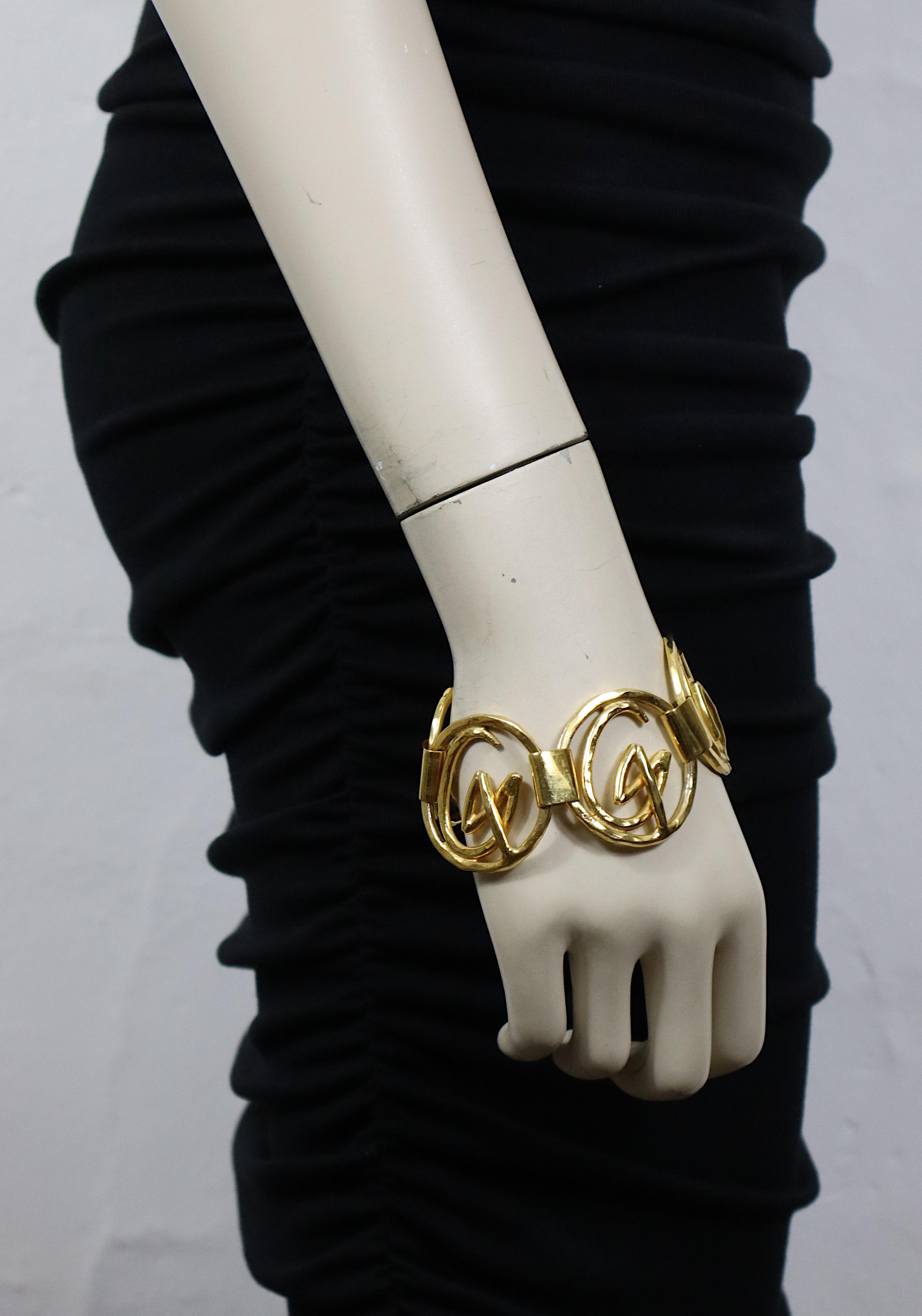 Bracciale iconico vintage Christian Lacroix in tonalità oro martellato con maglie rotonde ritagliate e logo Monogram CL.

Chiusura a gancio.

Marcato CHRISTIAN LACROIX CL Prodotto in Francia.

Misure indicative: lunghezza circa 20 cm (7,87 pollici)