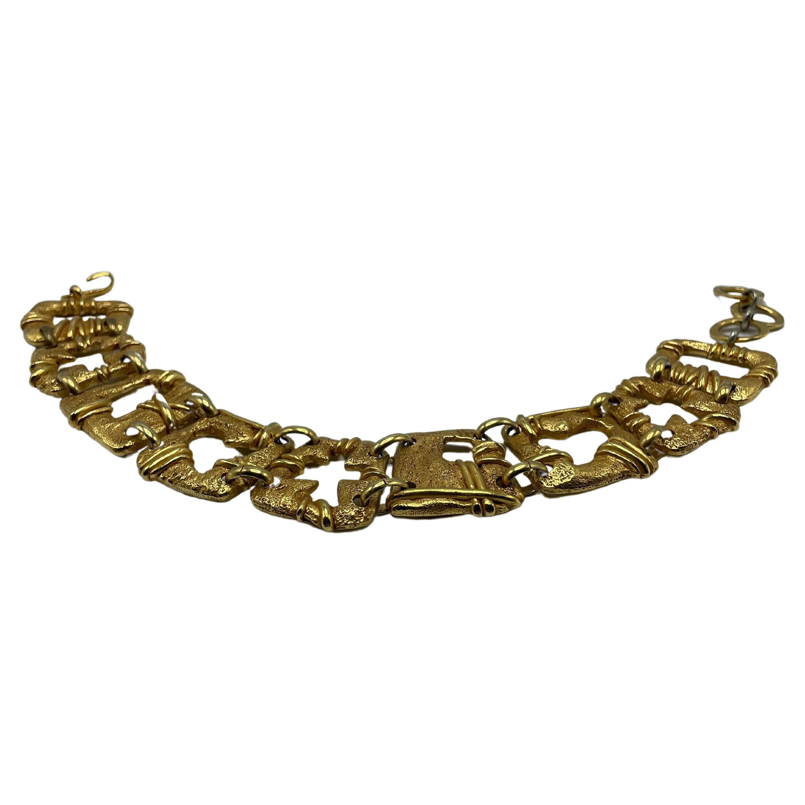 Christian Lacroix Vintage Gold Toned Choker Necklace. This necklace consists of nine squares with a hole in the center, a cross, a heart, and squares of varying sizes. 3 link for multiple sizes. 
Signature of Christian Lacroix Made in France.