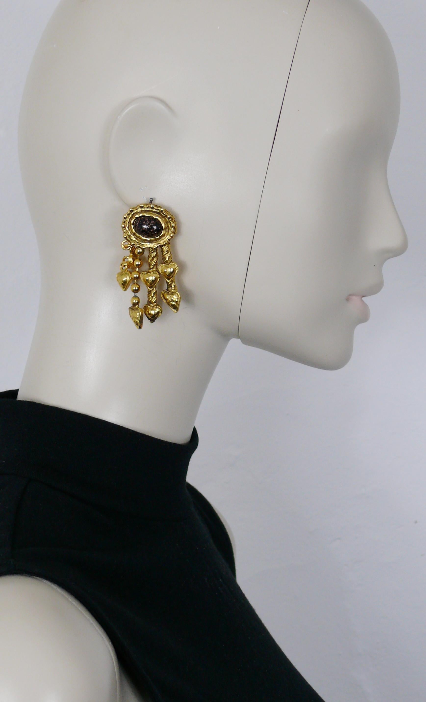 CHRISTIAN LACROIX Vintage-Ohrringe mit goldfarbener Struktur (Clip-on), verziert mit einem glitzernden braunen ovalen Glascabochon und Herzanhängern.

Geprägter CHRISTIAN LACROIX CL Made in France.

Ungefähre Maße: max. Höhe ca. 5,8 cm (2,28 Zoll) /