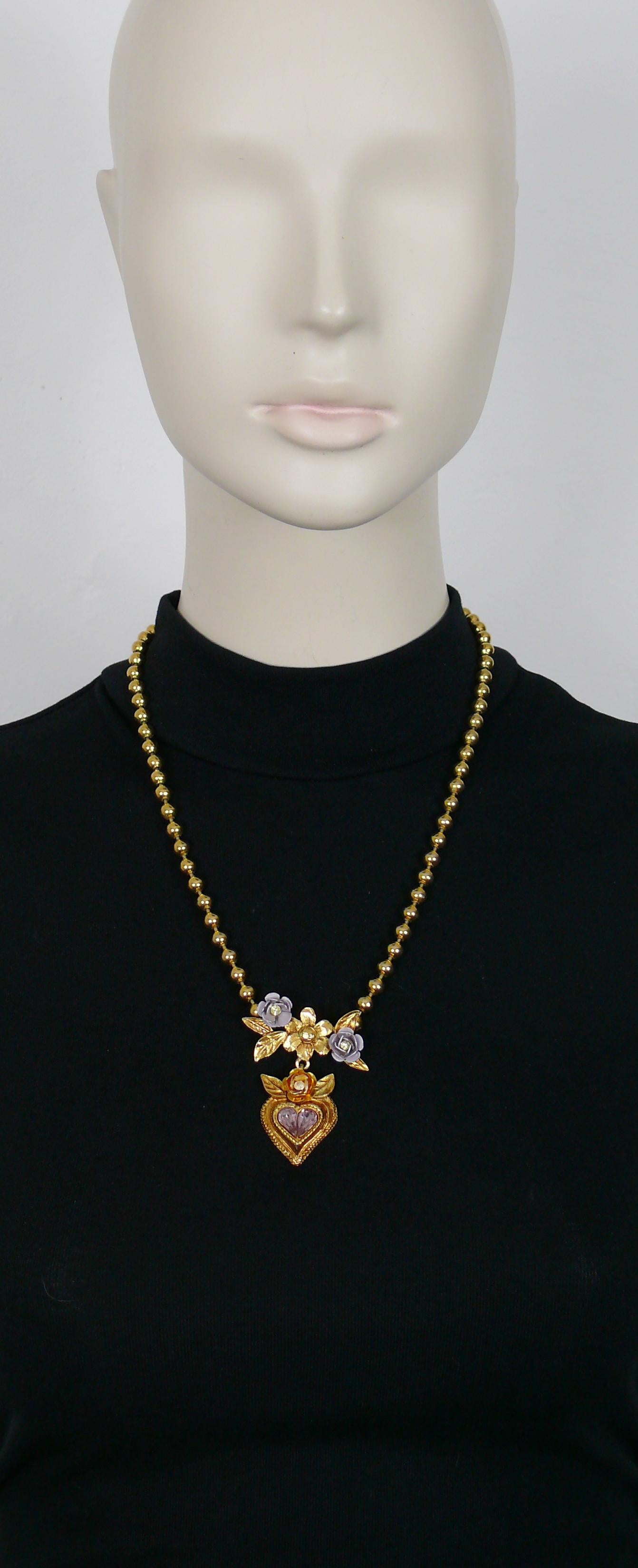 CHRISTIAN LACROIX Halskette mit goldfarbener Kugelkette und einem Herzanhänger mit Blumen, die mit fliederfarbenen und hellgelben Kristallen verziert sind.

Häkchenverschluss.

Gezeichnet CHRISTIAN LACROIX CL Made in France.

Ungefähre Maße: