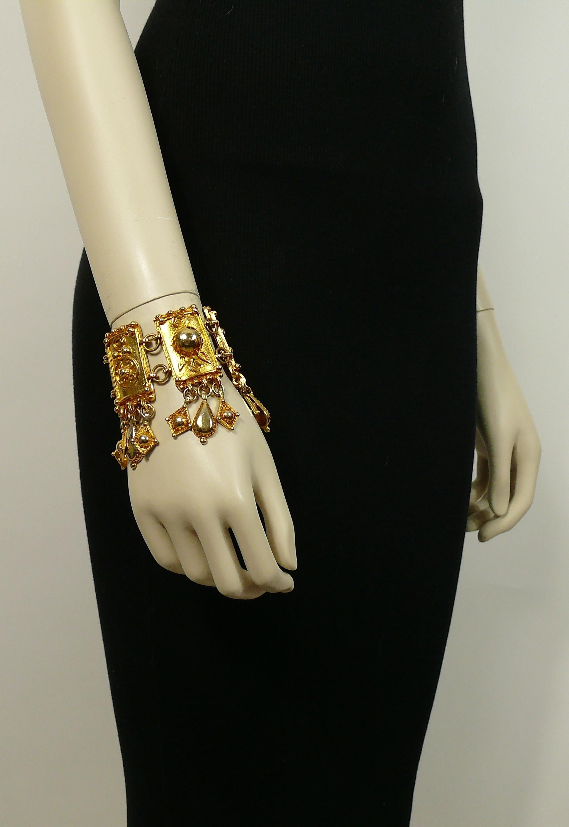 CHRISTIAN LACROIX vintage gold toned Oriental inspired bracelet featuring rectangular shield-like inks with geometric details and charms.

Marked CHRISTIAN LACROIX CL Made in France.

Indicative measurements : length approx. 16.7 cm (6.57 inches) /