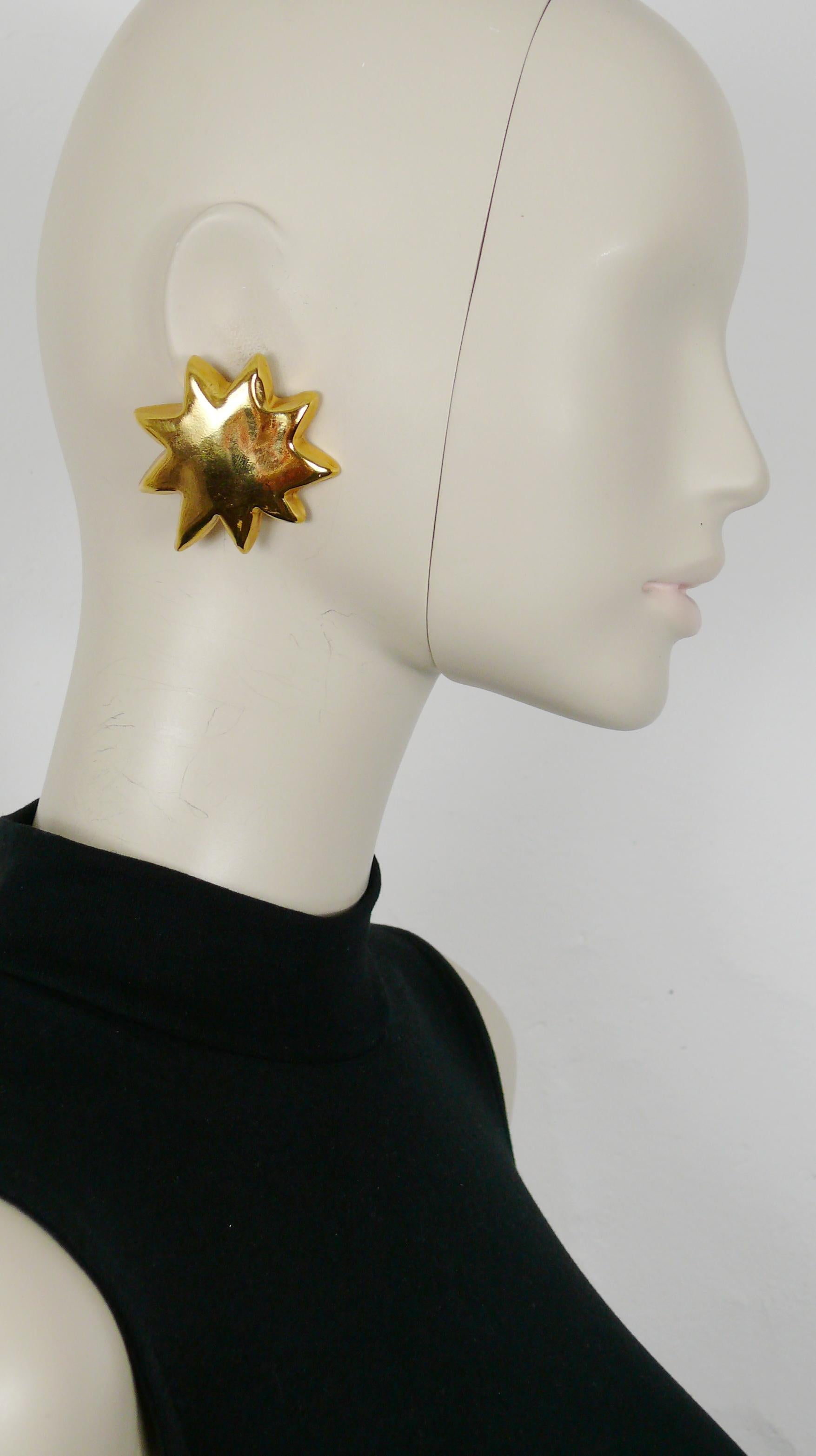 CHRISTIAN LACROIX Vintage-Ohrringe aus goldfarbenem Harz mit ikonischem Starburst als Clip-on.

Gezeichnet CHRISTIAN LACROIX CL Made in France.
Nur auf einem Ohrring (der andere ovale Signaturstempel ist heruntergefallen).

Ungefähre Maße: max.