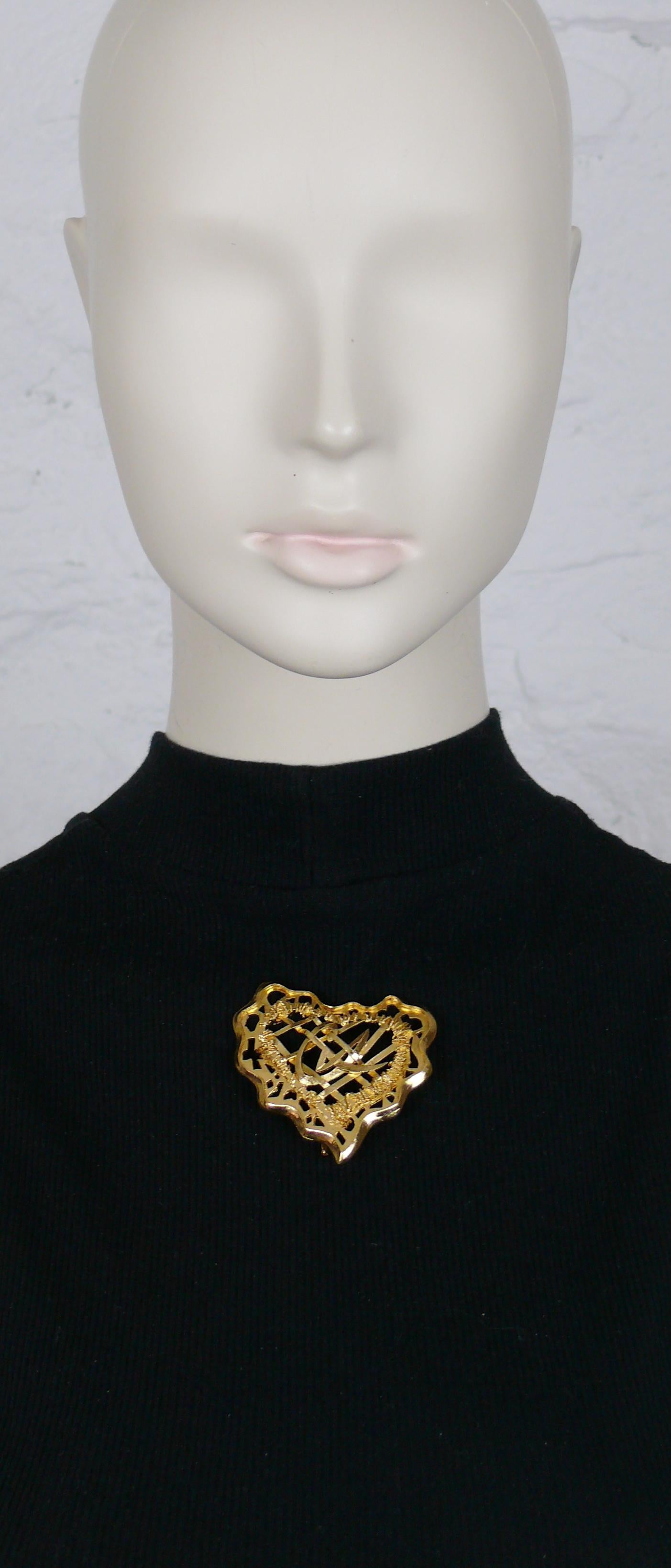 CHRISTIAN LACROIX vintage gold toned openwork grid design with CL logo heart brooch.

Marked CHRISTIAN LACROIX CL Made in France.

Indicative measurements : max. height approx. 5.4 cm (2.13 inches) / max. height approx. 5.6 cm (2.20