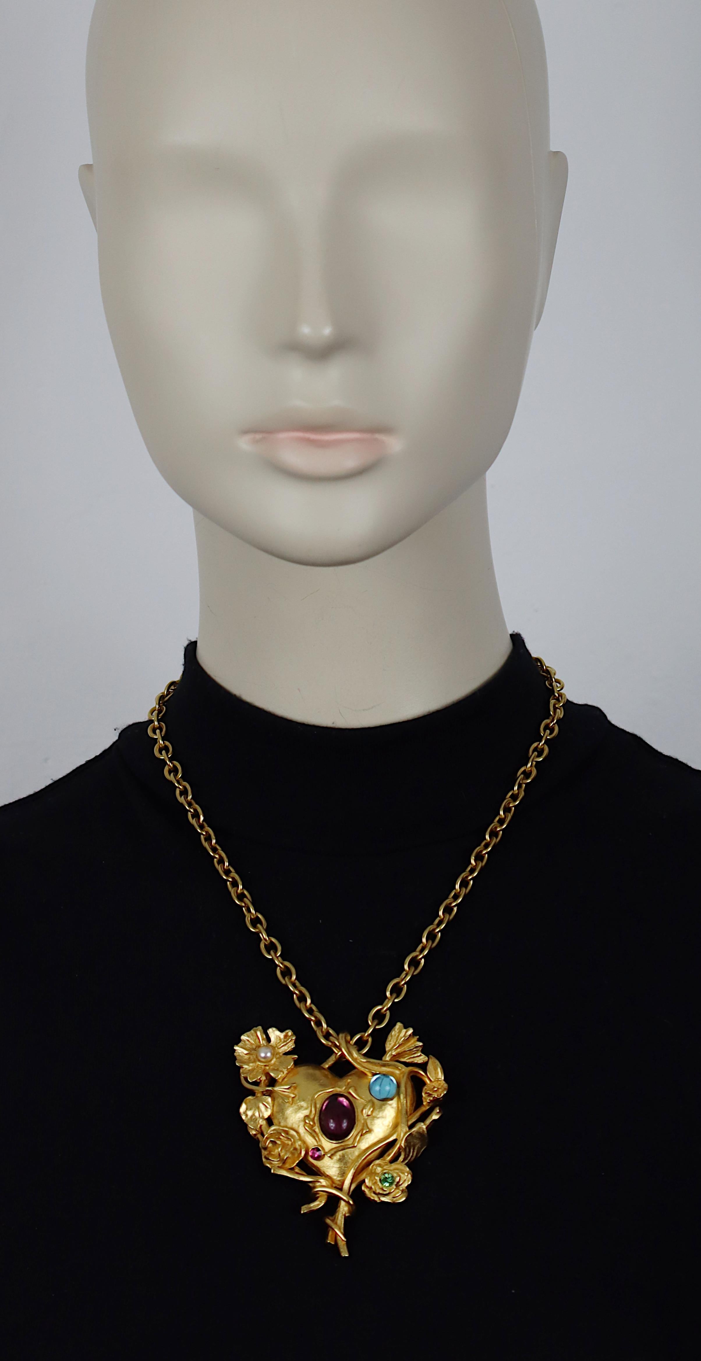 Collana vintage con catena dorata di CHRISTIAN LACROIX con un cuore floreale Jewell e specchiato impreziosito da cabochon di vetro blu e viola, perle finte e cristalli multicolori.

Marcato CHRISTIAN LACROIX CL Prodotto in Francia.

Misure