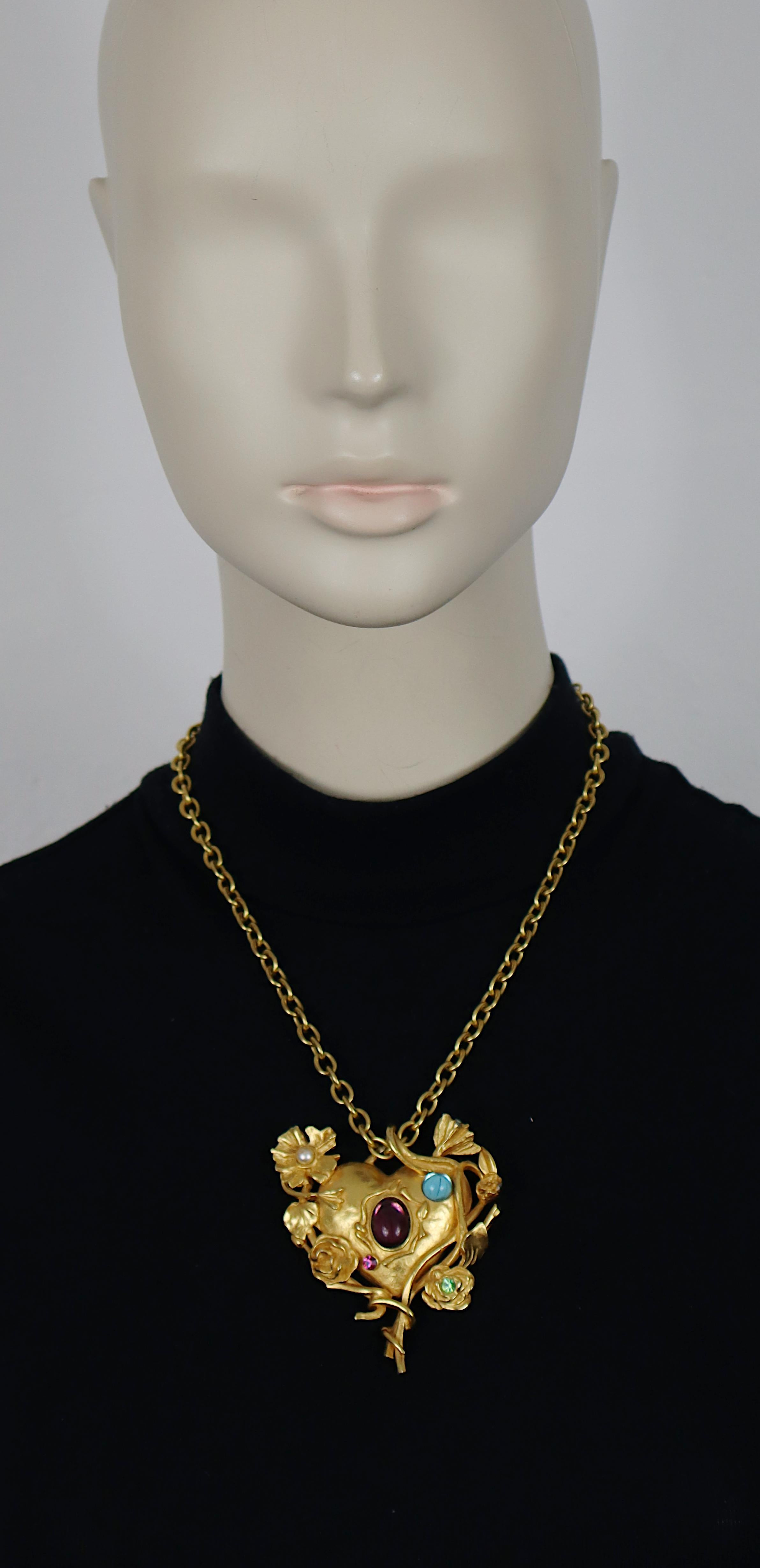 Collana vintage con catena dorata di CHRISTIAN LACROIX con un cuore floreale Jewell e specchiato impreziosito da cabochon di vetro blu e viola, perle finte e cristalli multicolori.

Marcato CHRISTIAN LACROIX CL Prodotto in Francia.

Misure