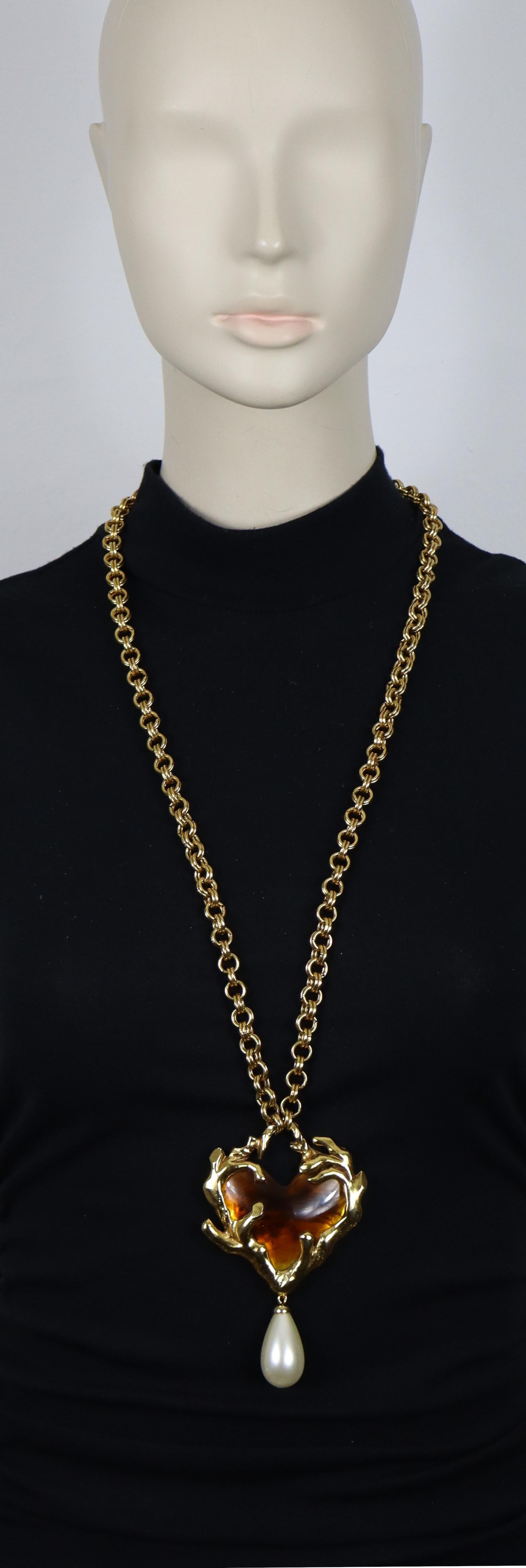 Collier CHRISTIAN LACROIX vintage en chaîne dorée avec un pendentif en forme de cœur massif. Le pendentif présente un cœur en résine marbrée de couleur ambre, élégamment serti dans une Branch de couleur or, ornée d'une perle en acrylique.

Fermoir à