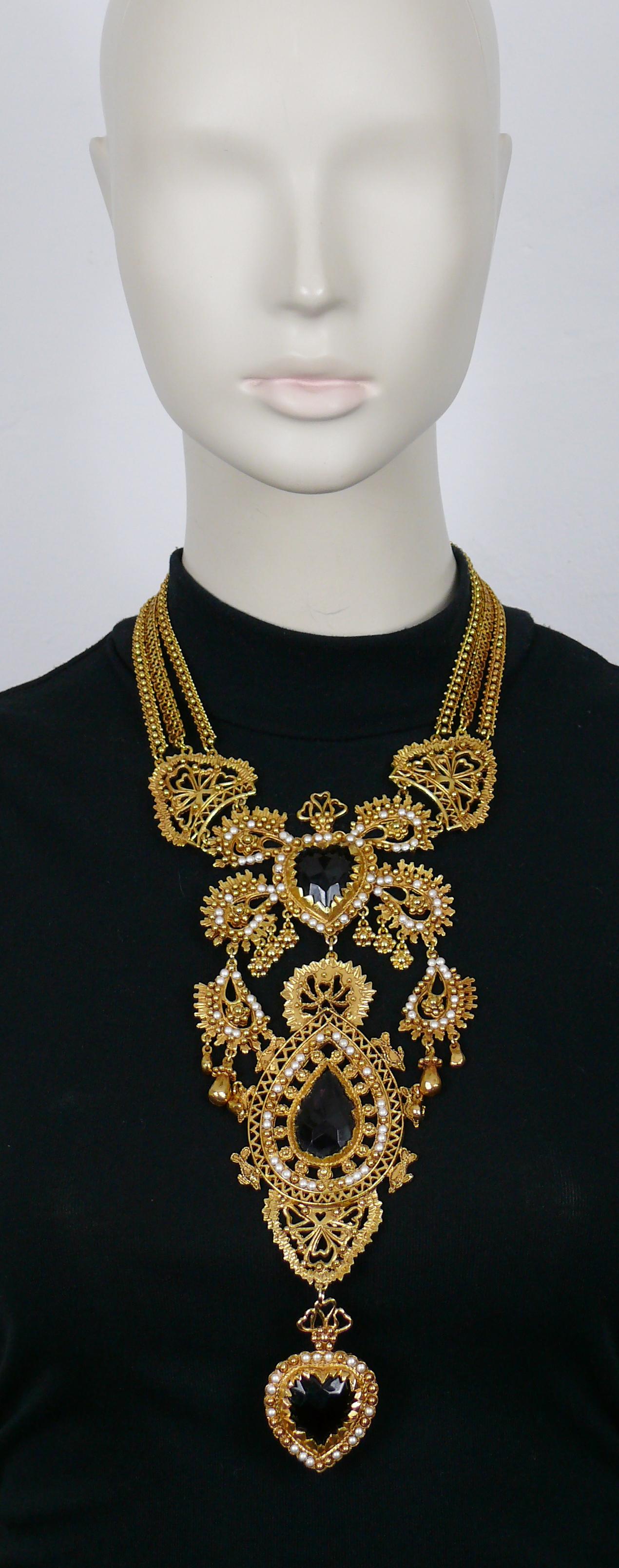 CHRISTIAN LACROIX vintage incredible opulent gold tone multi chain plastron necklace featuring ex voto sacred hearts, adorned with boteh-like design details, embellished with ruby/purple/black colour glass cabochons and small off-white pearls.

Hook