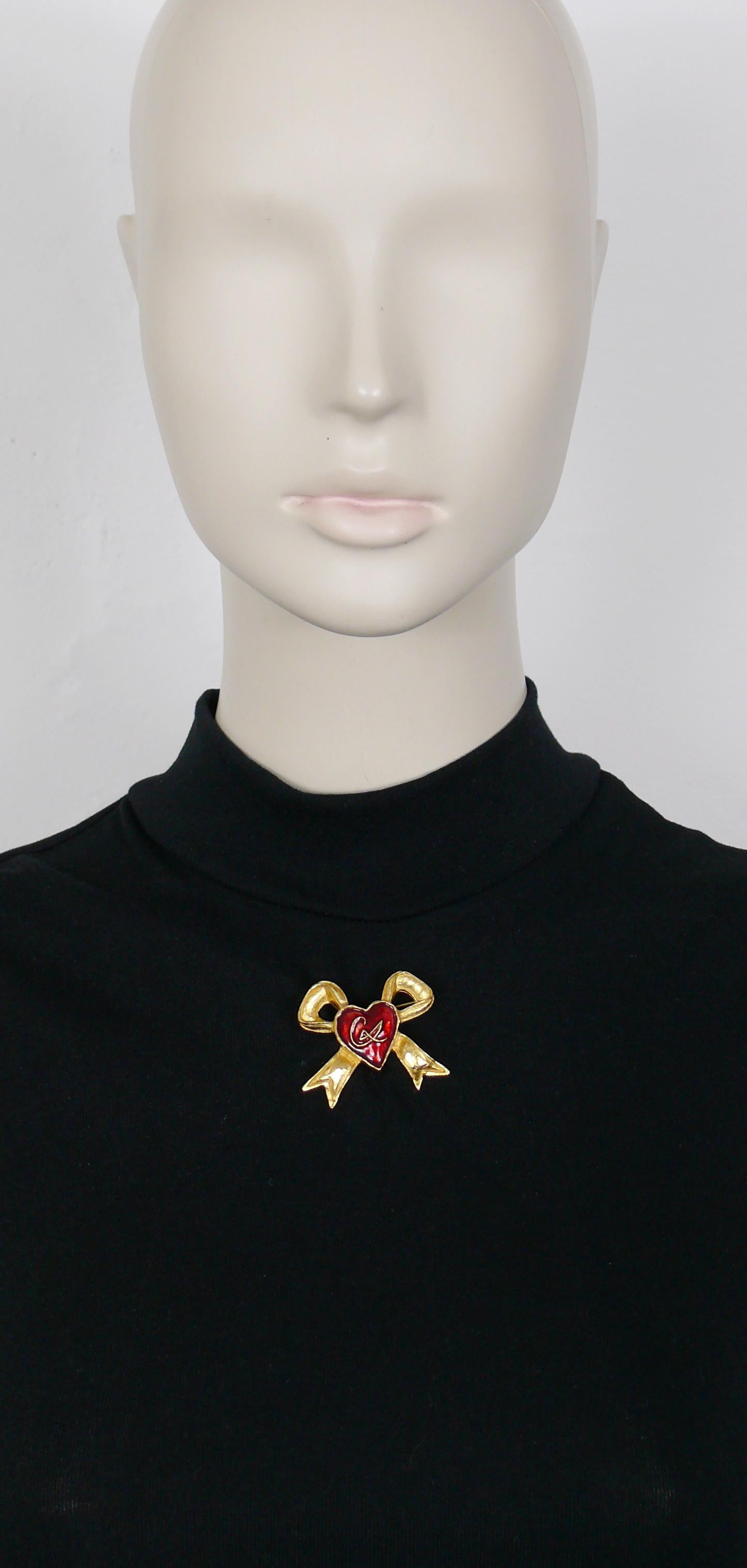 CHRISTIAN LACROIX vintage gold toned ribbon bow design brooch featuring a red enamel heart at the center with CL monogram.

Marked CHRISTIAN LACROIX CL Made in France.

Indicative measurements : max. height approx. 3.6 cm (1.42 inches) / max. width
