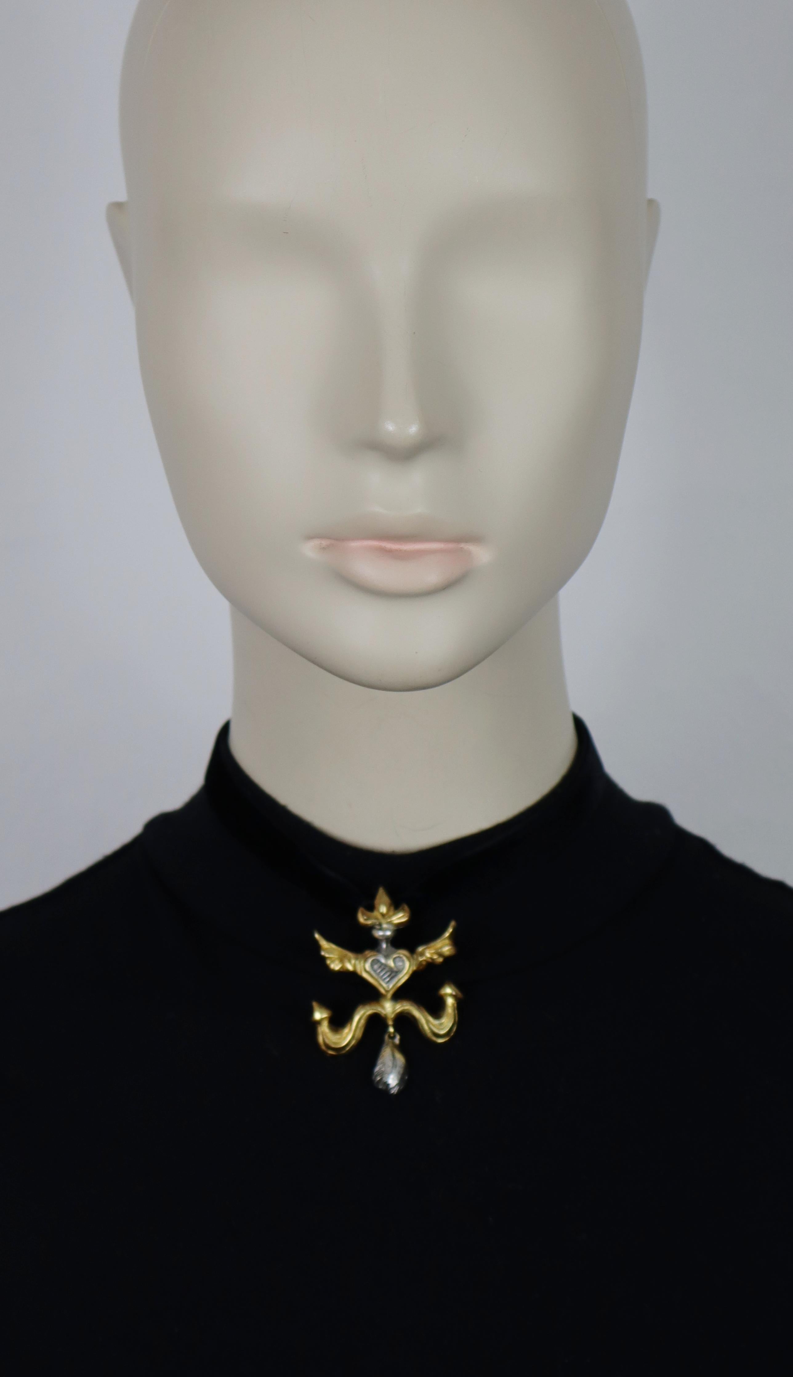Ciondolo CHRISTIAN LACROIX vintage anticato bicolore (oro/siviglia) con croce alata di Carmargue.

Nastro di velluto nero.
Legami intorno al collo.

Christian Lacroix CL Made in France in rilievo.

Misure indicative: lunghezza del nastro circa 79 cm